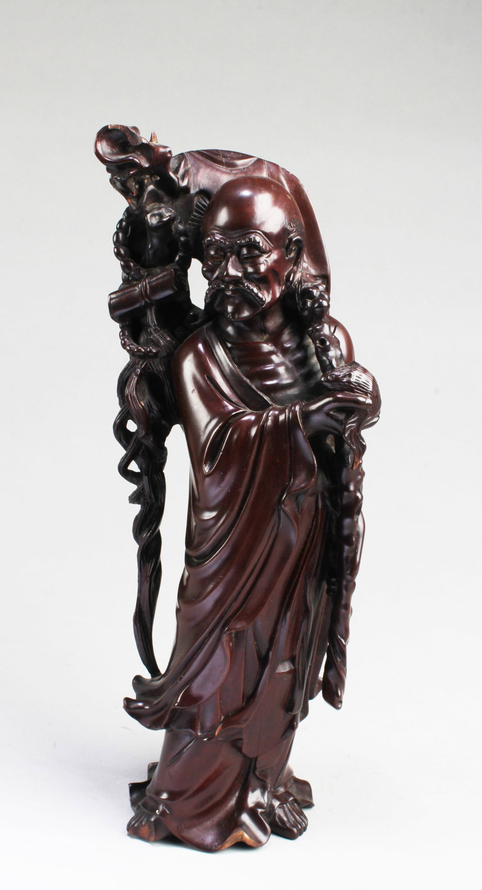 A Carved Wooden Figurine: A Carved Wooden Figurine. Height: 10"