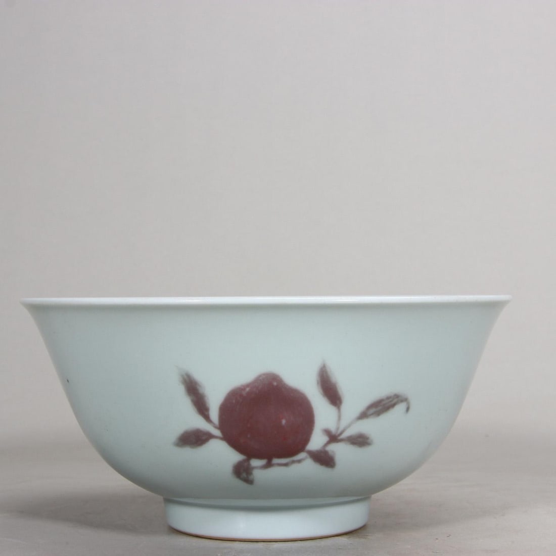 A COPPER RED "THREE ABUNDANCES" BOWL, YONGZHENG PERIOD, QING DYNASTY: H 8.7cm (3.43 in); D 18.8cm (7.4 in)A Yongzheng period copper red bowl, decorated with "Three Abundances" fruits. Clear mark at base, well-preserved, a fine imperial porcelain example.