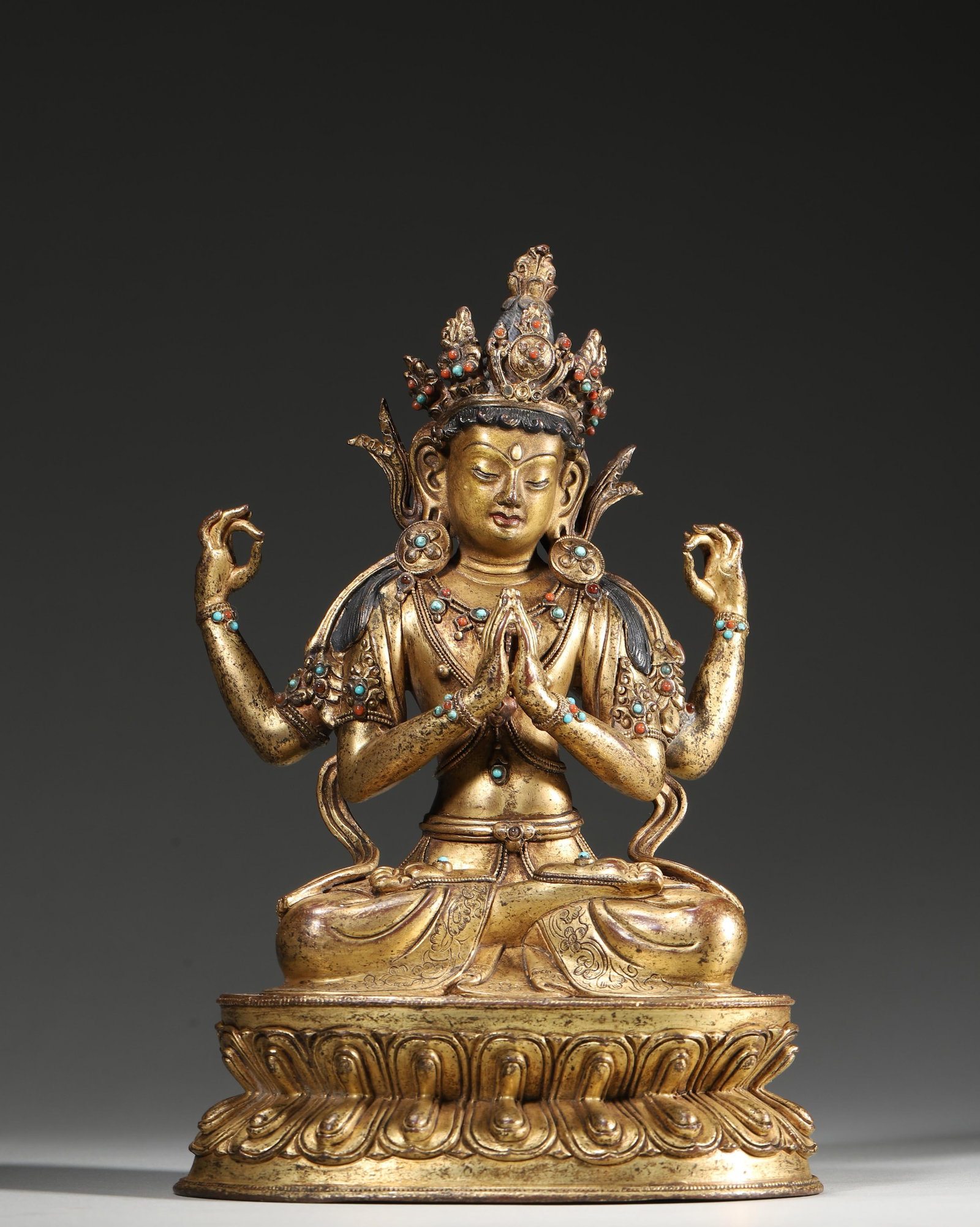 A GILT-COPPER ALLOY FIGURE OF FOUR-ARMED AVALOKITESHVARA WITH INLAID STONES, 17TH-18TH CENTURY: 5.51in x 4.33in x 8.27in (14.0cm x 11.0cm x 21.0cm), 3.382lb (1534.0g)This 17th-18th century gilt-copper four-armed Avalokiteshvara features serene features, inlaid turquoise and coral, and a double-l