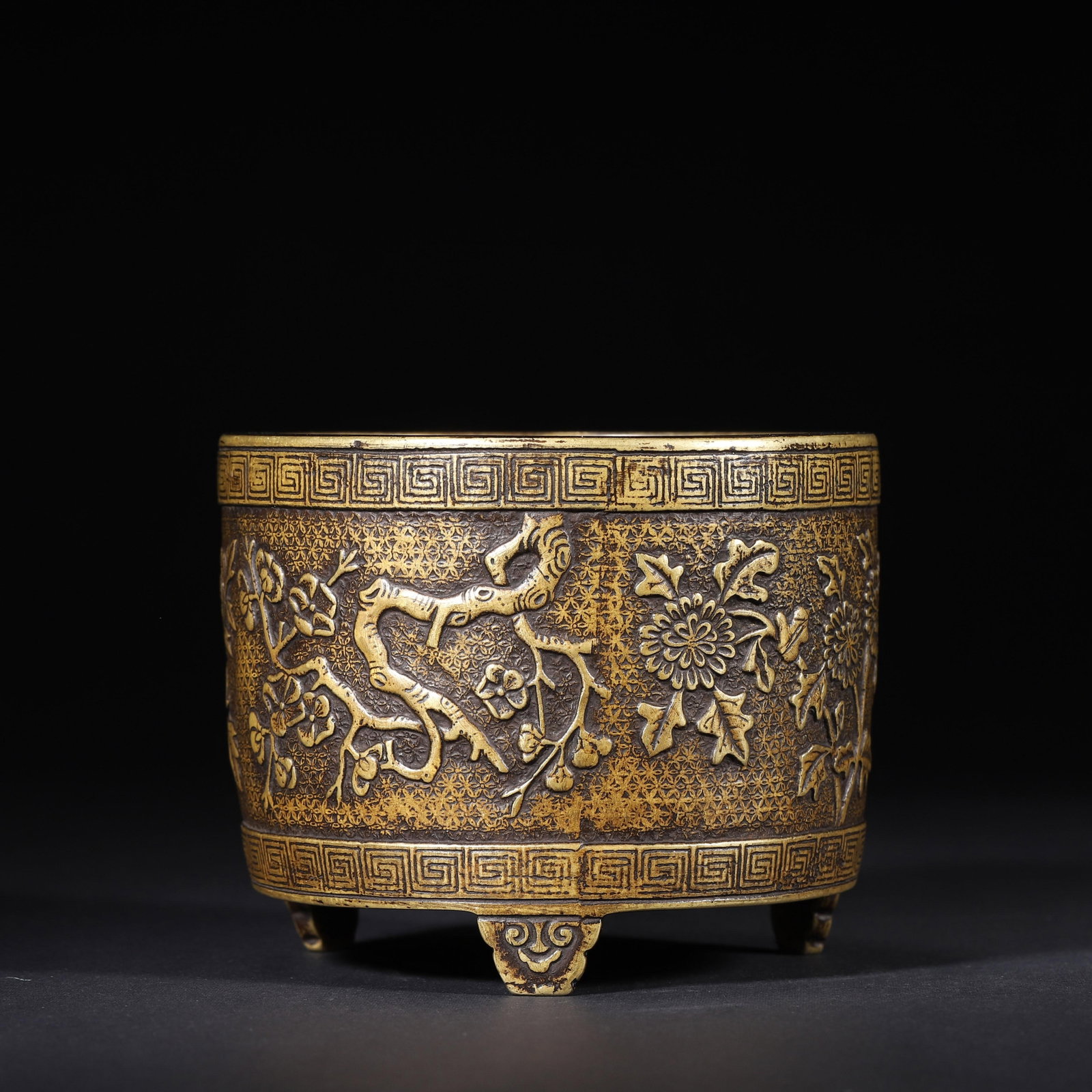 QING DYNASTY BRONZE TRIPOD CENSER WITH CARVED FOUR SEASONS FLORAL MOTIFS: 4.33" x 3.54" (11.0cm x 9.0cm) | 2.93lb (1329g)This refined Qing Dynasty bronze tripod censer features intricate relief carvings of four seasons flowers on a brocade ground. Its robust form, cloud-sha
