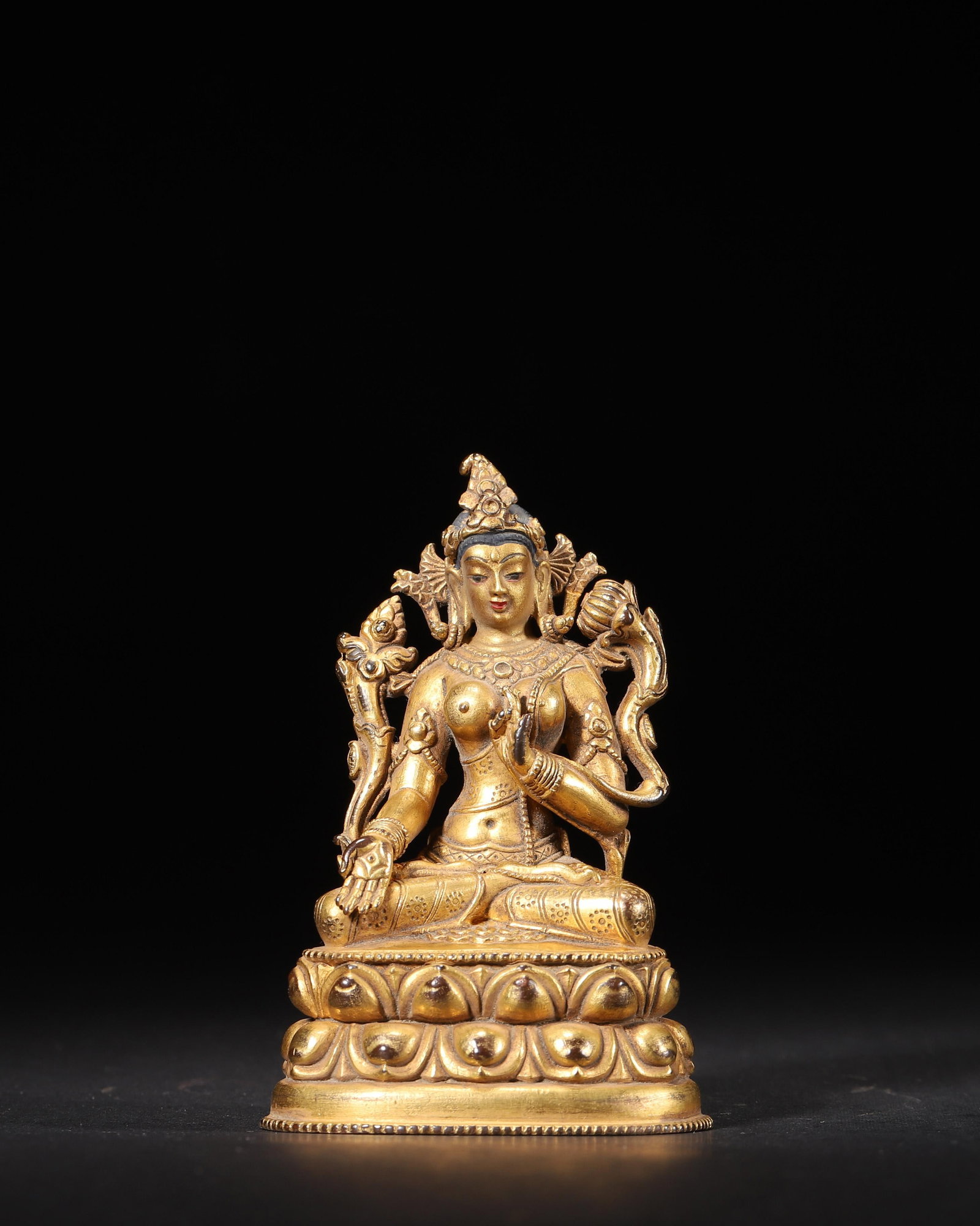 A GILT-BRONZE TARA STATUE, QING DYNASTY: 187.0 g (0.41 lb) | 5.6 x 4.5 cm (2.2 x 1.77 in)This Tara statue is made of refined bronze with a rich and full gilded finish. It features an elegant and serene facial expression, adorned with a five-