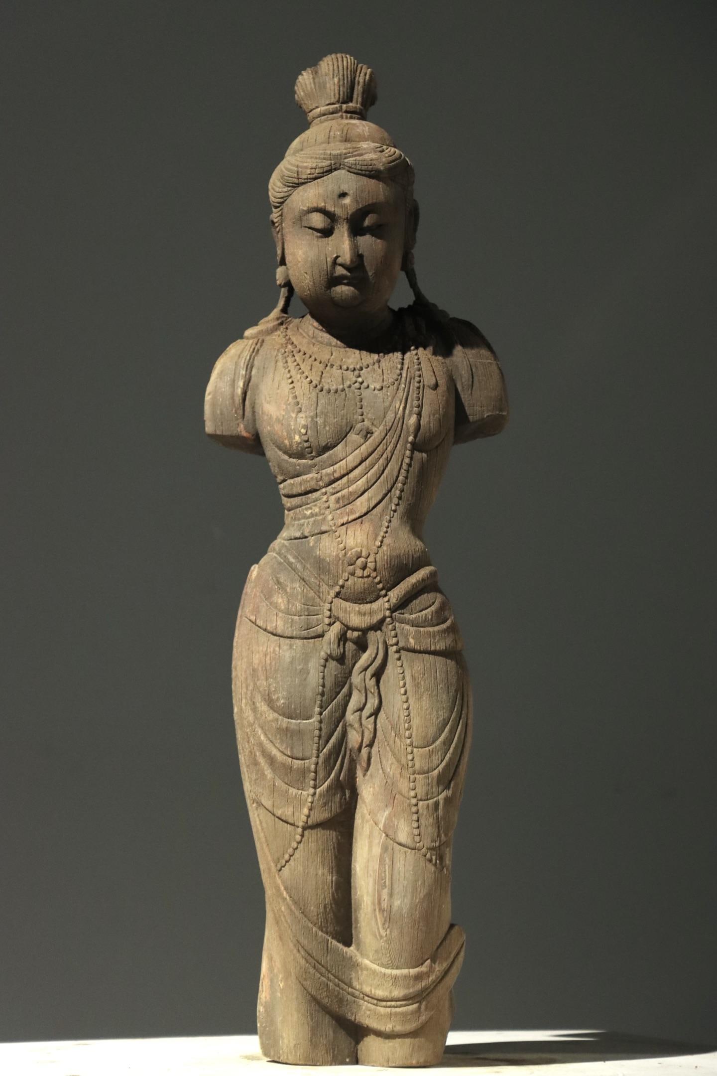 TANG BAOMU GUANYIN'S MUTILATED FIGURE: H:68cm(26.77in)Weight:15000gAn antique half-body wooden remnant statue of Guanyin with a high topknot and gentle facial features, fully carved with multi-layer pearl necklaces and smooth drapery, show
