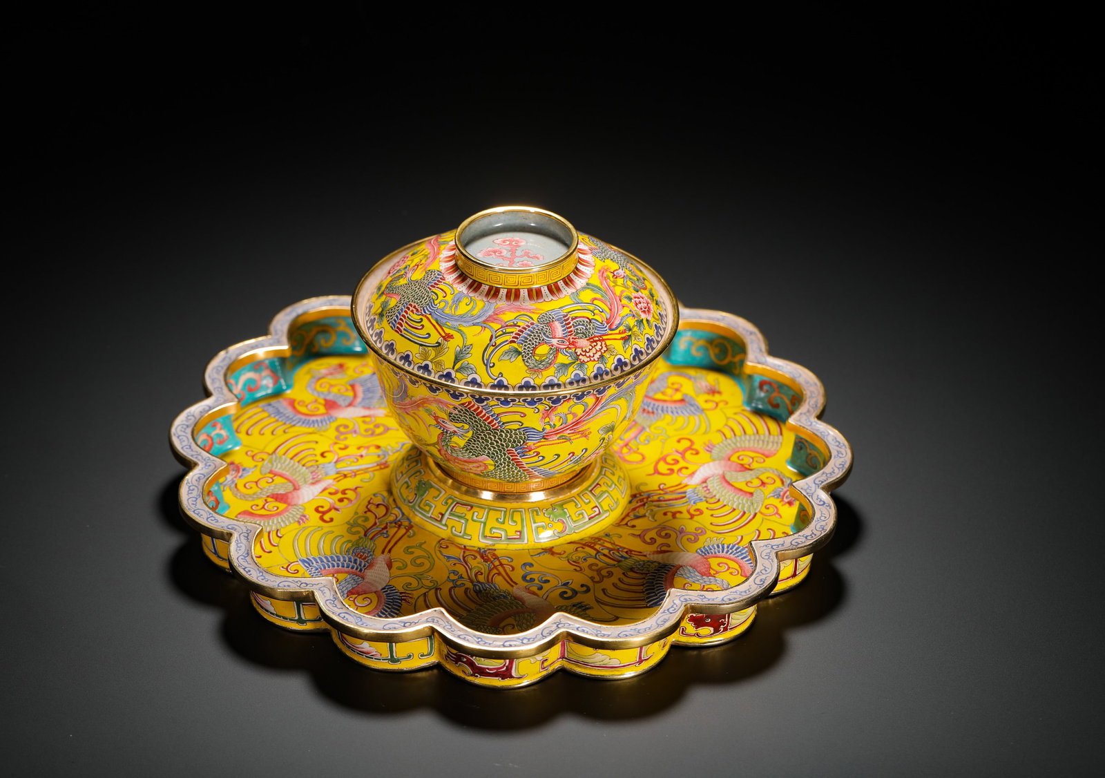 QING DYNASTY COPPER BODY PAINTED ENAMEL DRAGON AND PHOENIX PATTERN COVERED BOWL WITH SAUCER: H:13cm(5.12in)W:22.5cm(8.86in)Weight:1070g(2.36lb)These objects were used as imperial tea sets, reflecting the court's taste and etiquette. The dragon and phoenix motifs symbolized harmony and prosper