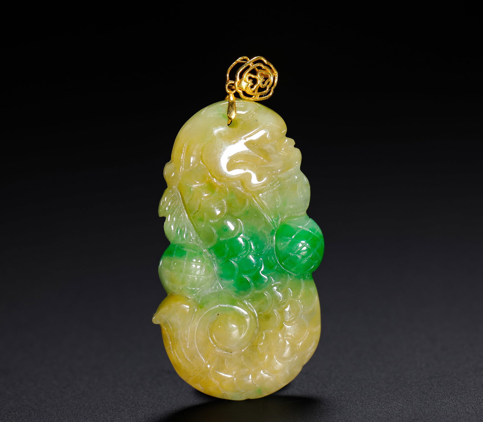 A YELLOW AND GREEN JADE FISH-TRANSFORMED DRAGON PENDANT FROM THE QING DYNASTY: H:3.5cm (1.38in) W:2cm (0.79in) Weight:6.5g (0.01lb)