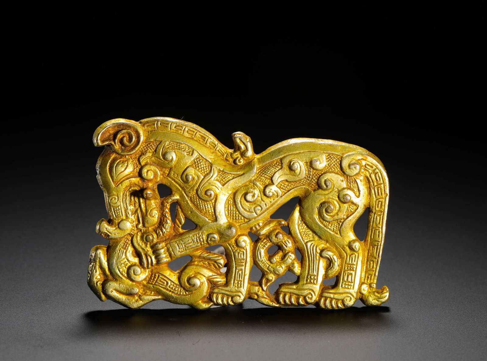 WARRING STATES PERIOD GOLD INLAID DIVINE BEAST PATTERN BELT BUCKLE: H:5.5cm(2.17in) W:9cm(3.54in) Weight:100g(0.22lb)Worn by nobility, these buckles served both functional and decorative purposes, symbolizing status and reflecting the cultural reverence for powerful b