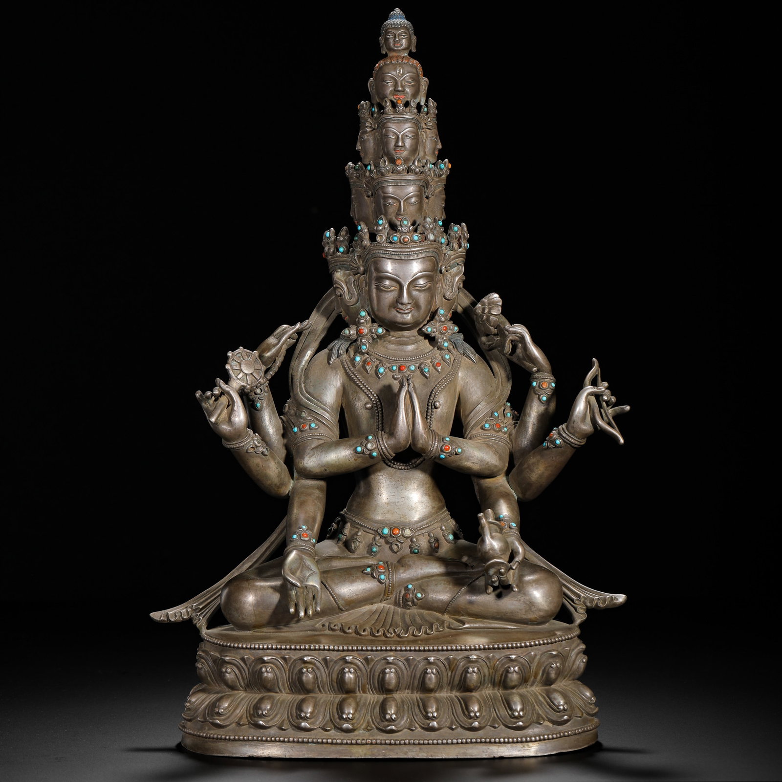 A SILVER SEATED STATUE OF GUANYIN BODHISATTVA WITH EIGHT ARMS AND ELEVEN FACES FROM THE QING DYNASTY: H:38.3cm (15.08in) W:26cm (10.24in) Weight:5110g (11.27lb)This is a Qing Dynasty silver seated statue of the eight-armed and eleven-headed Guanyin in the Tibetan Buddhist style, featuring exquisite cr