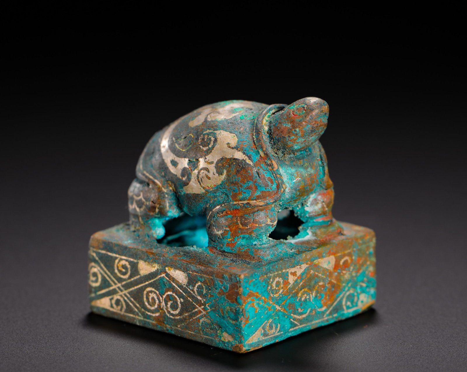 BRONZE INLAID SILVER TURTLE BUTTON SQUARE SEAL FROM THE WARRING STATES PERIOD TO THE HAN DYNASTY: H:3.8cm (1.50in) W:3.8cm (1.50in) Weight:180g (0.40lb)Bronze private seal decorated with full silver inlay on knob and body, archaic zhuwen script on seal face.