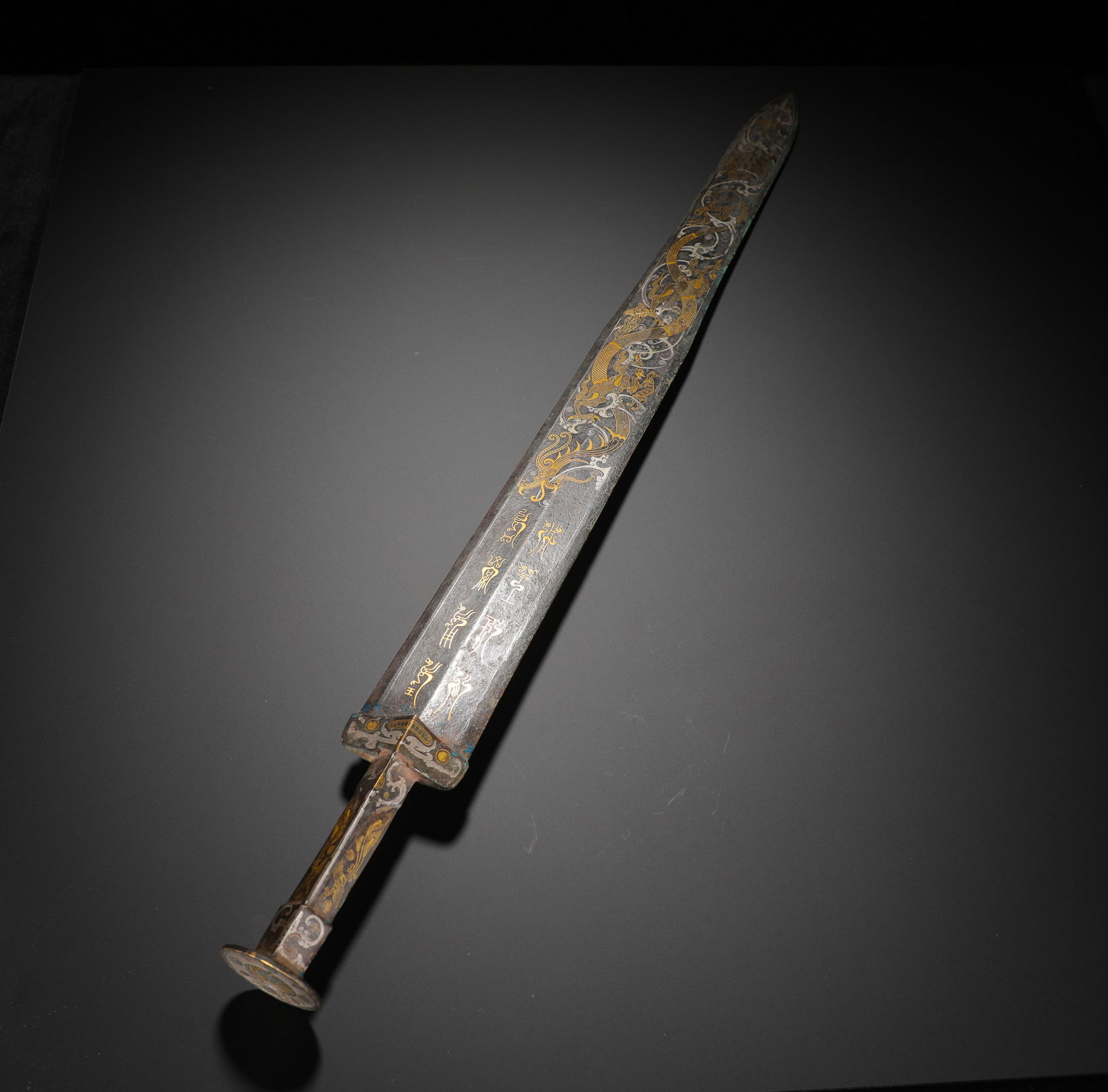 BRONZE INLAID GOLD AND SILVER INSCRIPTIONS SWORD OF THE HAN DYNASTY: H:60cm(23.62in)Weight:950g(2.09lb)These objects were both weapons and symbols of status. The inscriptions recorded the sword's origin and the owner's rank, reflecting the craftsmanship and artistry of