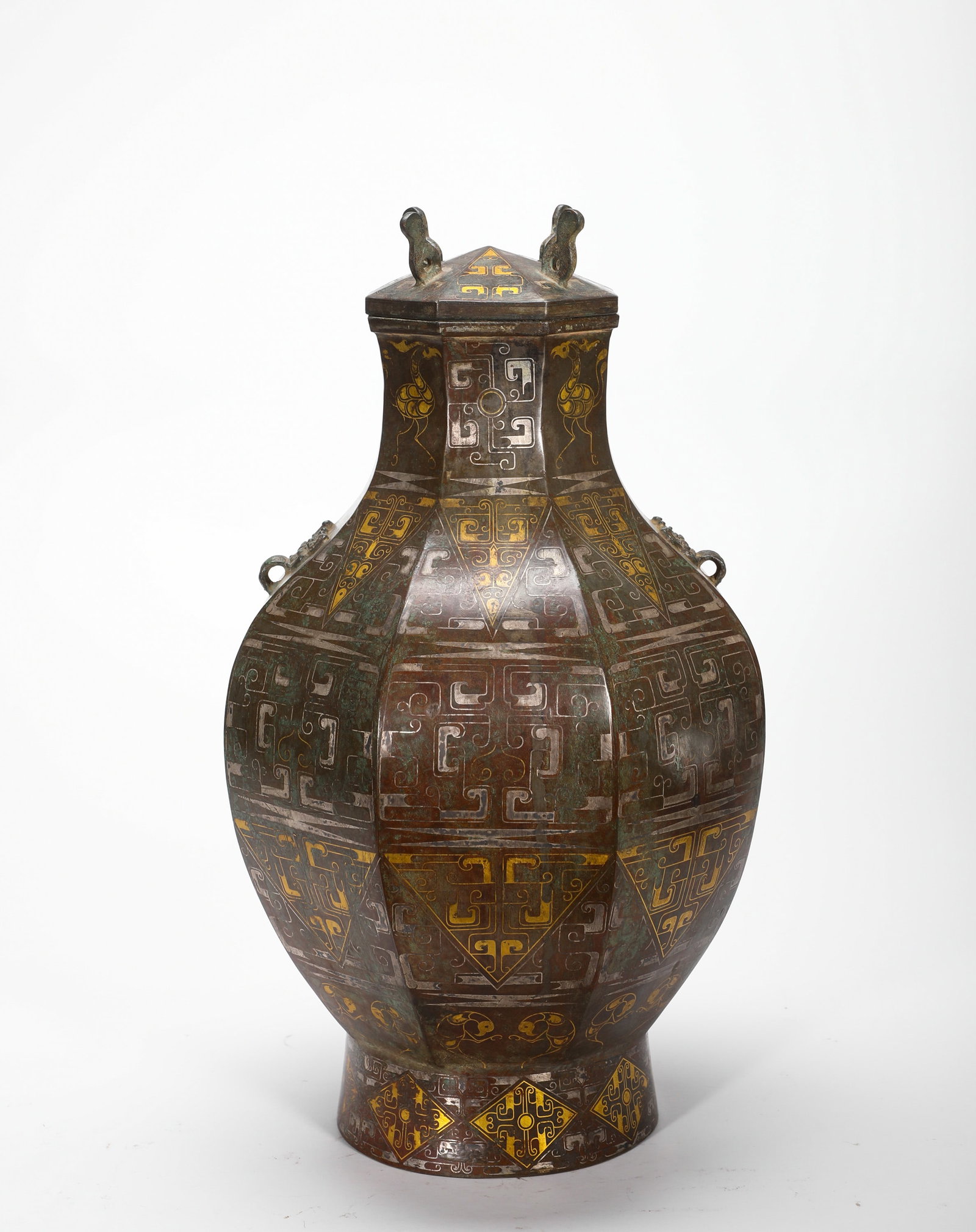 HAN DYNASTY BRONZE INLAID GOLD AND SILVER GEOMETRIC PATTERN OCTAGONAL COVERED POT: H:38cm(14.96in)W:18cm(7.09in)Weight:4030g(8.89lb)This is an exemplary ritual bronze vessel from the Warring States to Han period, used by the nobility to hold wine or water.
