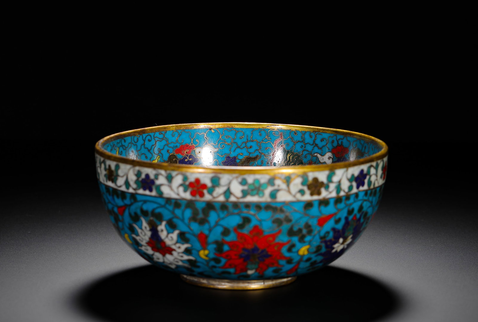 A BOWL WITH A COPPER BODY AND CLOISONNE ENAMEL WITH LOTUS PATTERNS: H:7cm (2.76in) D:15cm (5.91in) Weight:680g (1.50lb)Gilt interior cloisonne bowl, turquoise ground interlocking lotus, Jingtai reign mark on gilded base.