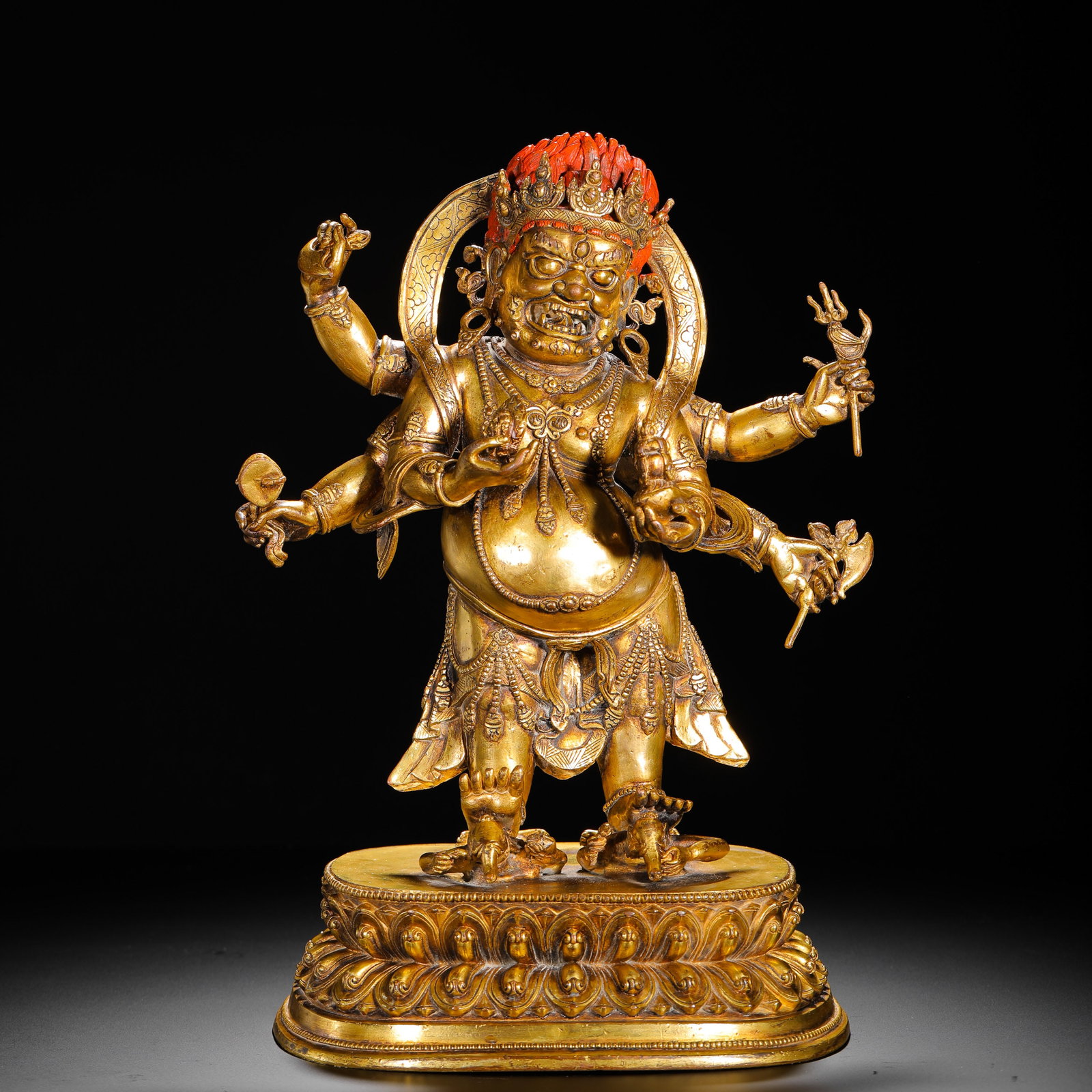 A GILDED BRONZE SIX-ARMED MAHAGALA PROTECTOR FROM THE QING DYNASTY: H:35cm (13.78in) W:23cm (9.06in) Weight:4910g (10.82lb)This is a Qing Dynasty gilt bronze statue of the six-armed Mahakala protector in the Tibetan Buddhist style, featuring exquisite craftsmanship an