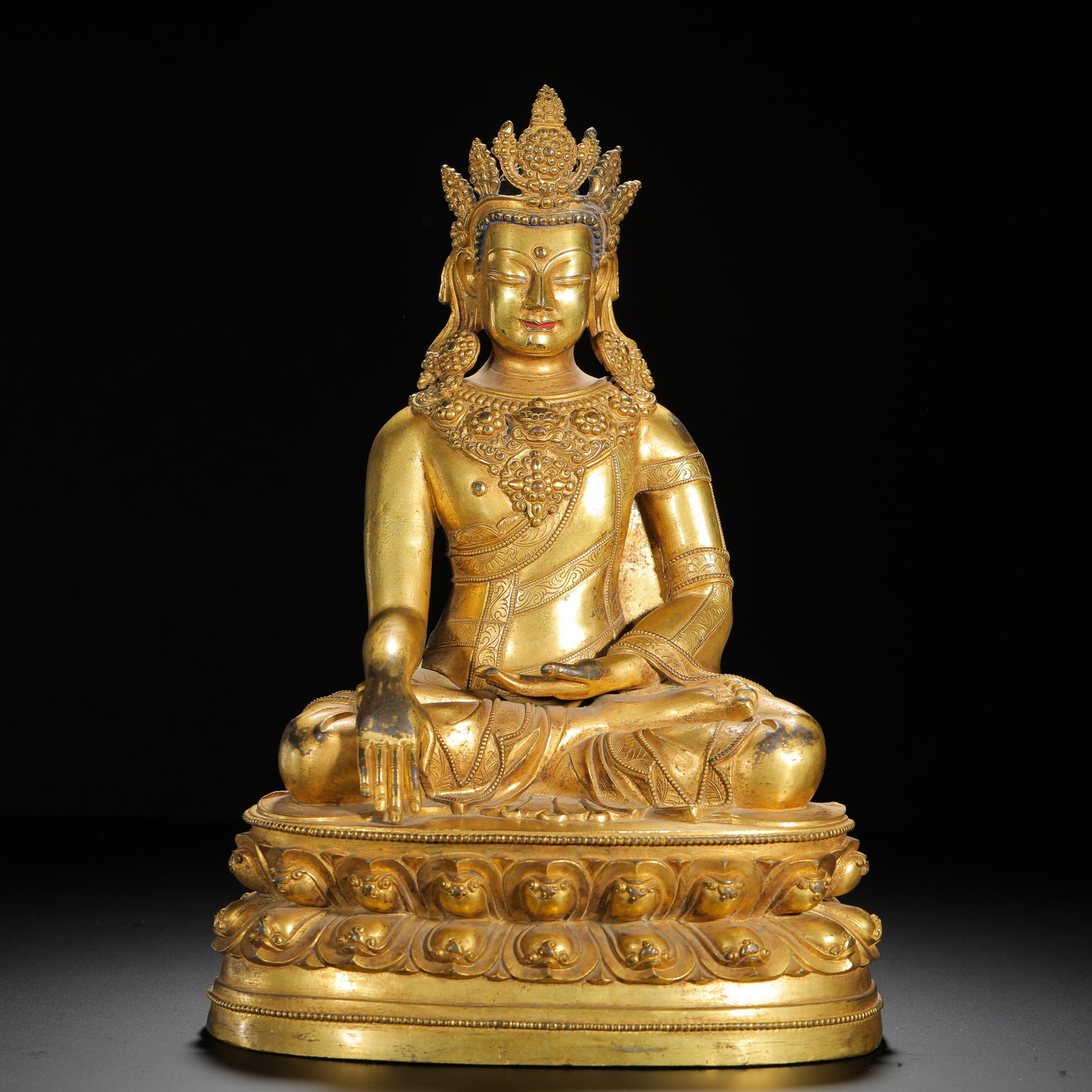 A SEATED STATUE OF SAKYAMUNI BUDDHA WITH A GILDED BRONZE CROWN FROM THE QING DYNASTY: H:31cm (12.20in) W:22cm (8.66in) Weight:4960g (10.93lb)This is a Qing Dynasty gilt bronze seated statue of crowned Shakyamuni Buddha in the Tibetan Buddhist style, featuring exquisite craftsmanship an