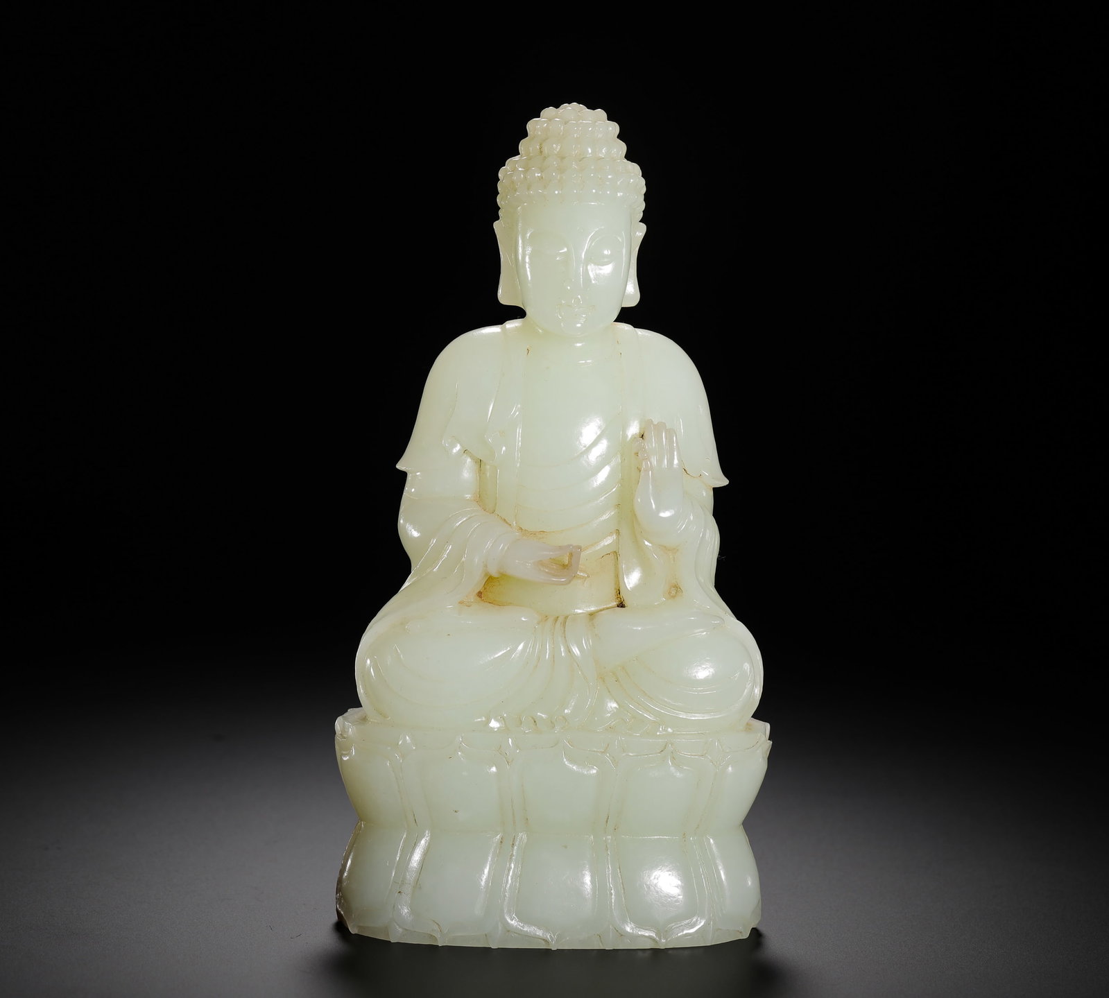 SEATED STATUE OF SAKYAMUNI IN HETIAN JADE OF THE QING DYNASTY: H:16cm (6.30in) W:8.5cm (3.35in) Weight:720g (1.59lb)H:16cmW:8.5cmWeight:720g This seated Buddha statue is a Buddhist-themed jade work from the Qing Dynasty, crafted from lustrous Hetian celadon white