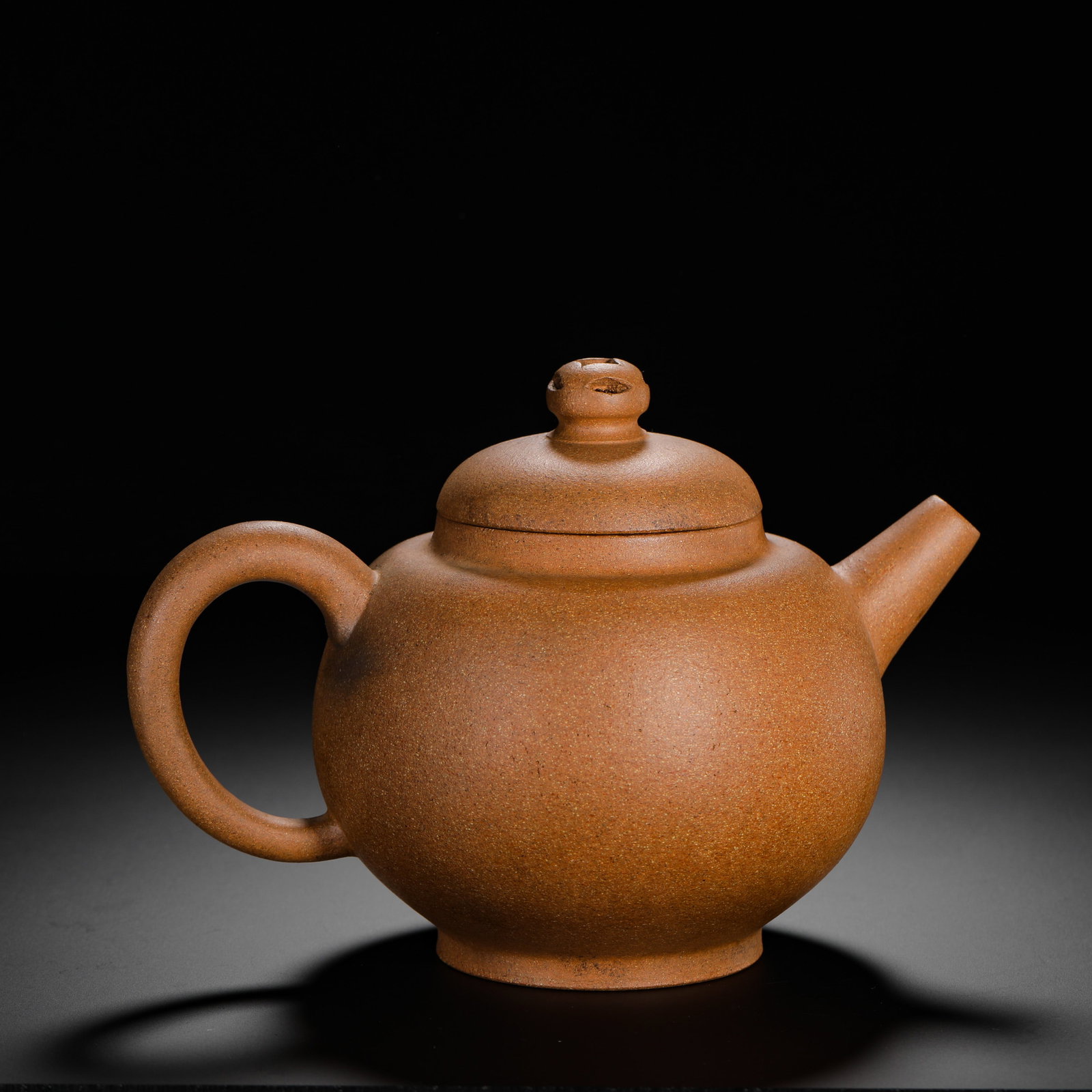 QING DYNASTY PURPLE CLAY TEAPOTS: H:14cmW:19.5cmWeight:420g Plain-style round Zisha teapot made of golden Duan clay with distinct fine sand grains. Plump spherical body, straight short spout, circular handle, hollowed lotus seedpod kn