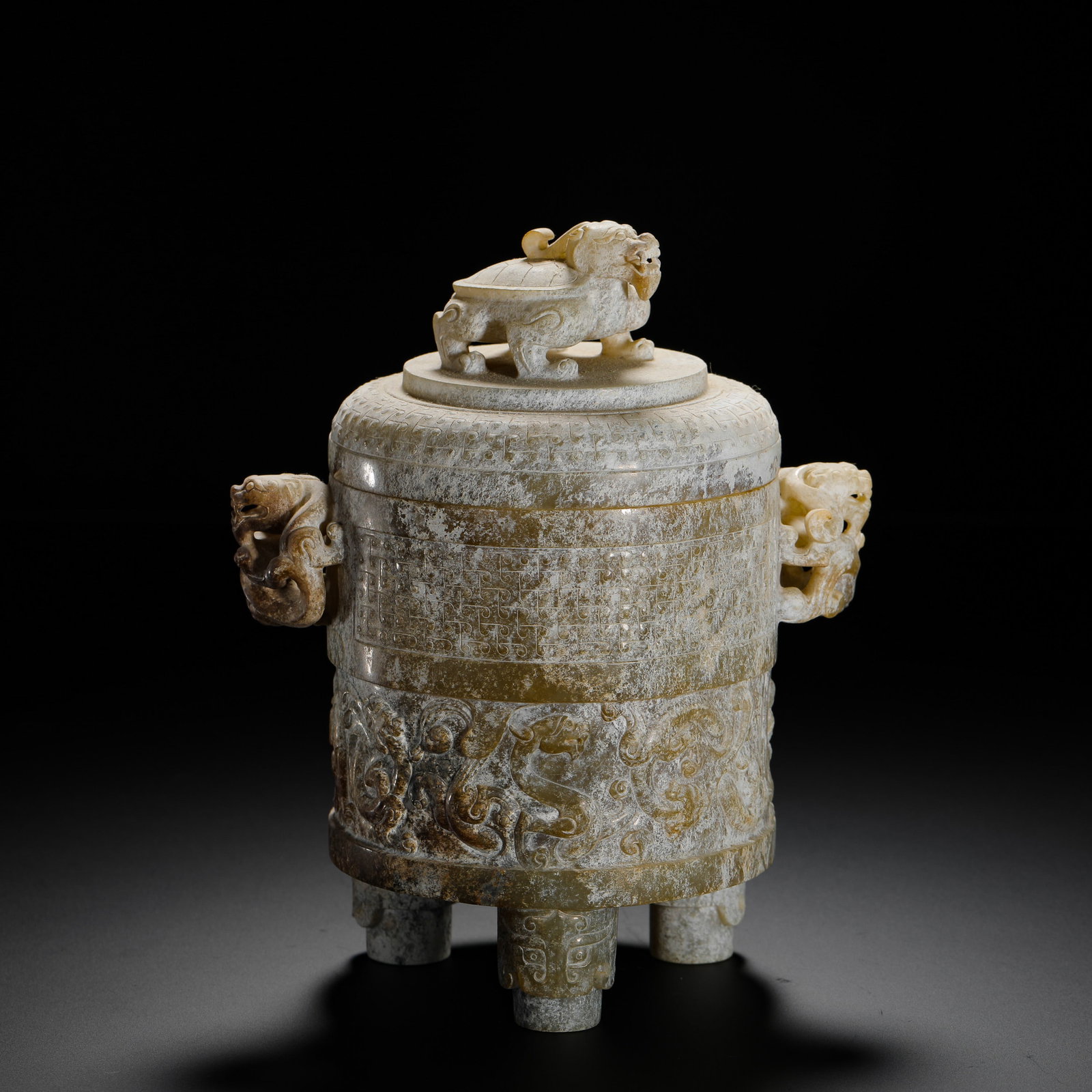 HAN DYNASTY DRAGON TURTLE BUTTON DOUBLE CHI DRAGON EAR THREE-LEGGED CUP: H:17cmW:13cmWeight:740g Han ritual jade tripod vessel topped with dragon-tortoise knob, flanked by openwork chi dragon handles, decorated with grain and dragon patterns, fully covered in ancient calci