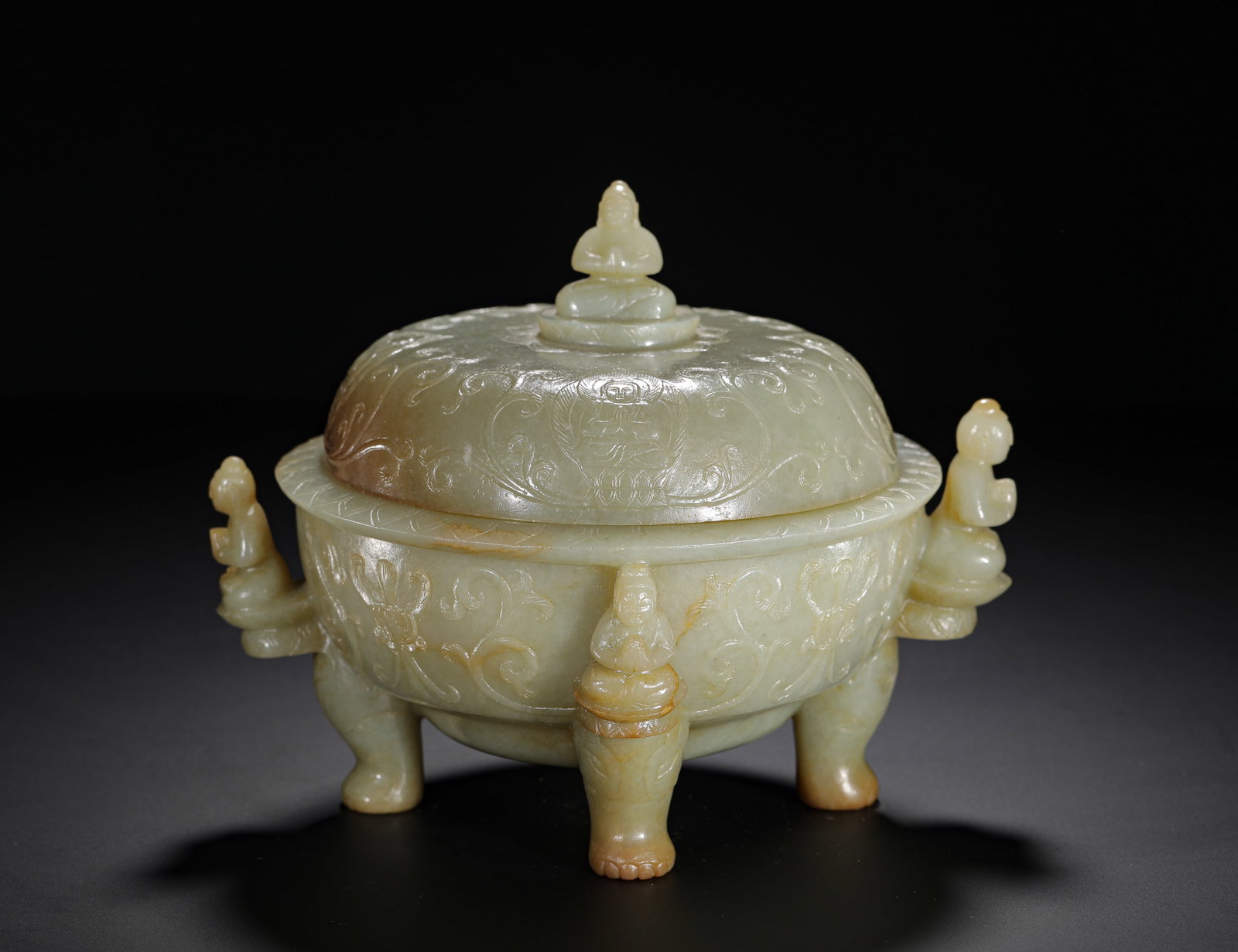 QING DYNASTY HETIAN JADE BUDDHA STATUE KNOB FLOWER-PATTERNED THREE-LEGGED STOVE: H:18cm(7.09in) W:19cm(7.48in) Weight:1230g(2.71lb)This is a Qing Dynasty Hetian jade tripod censer, topped with a Buddha finial and decorated with carved scrolling floral patterns on the body and lid.