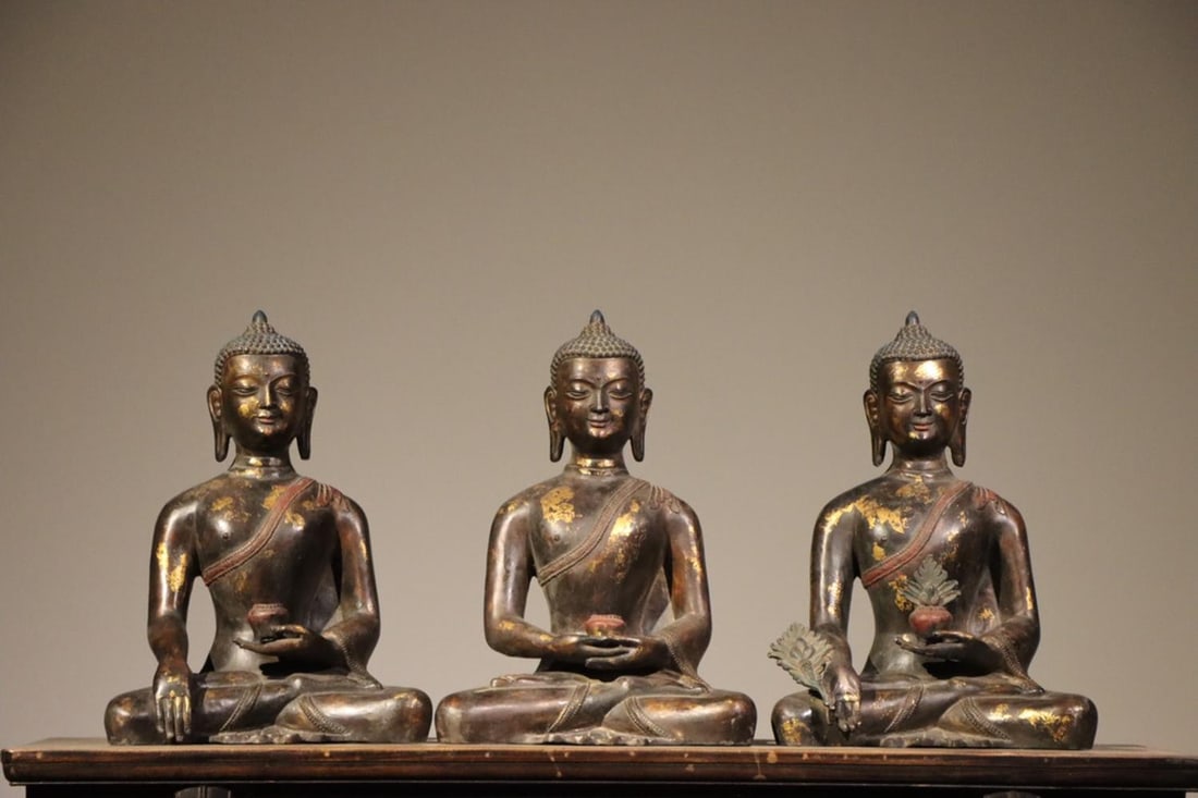 QING DYNASTY GILDED BRONZE STATUE OF THE THREE BUDDHAS (: H:40cm(15.75in)W:28cm(11.02in)T:18cm(7.09in)From left to right, they are respectively Dipankara Buddha (Past Buddha), Sakyamuni Buddha (Present Buddha) and Medicine Buddha (Future Buddha). Each statue