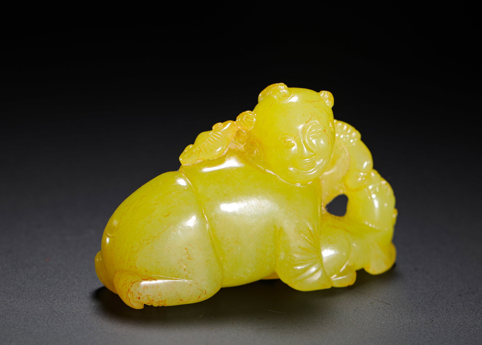 QING DYNASTY HETIAN YELLOW JADE BOY PLAYING WITH BEASTS PENDANT: H:3.6cm (1.42in) W:6cm (2.36in) Weight:50g (0.11lb) This pendant is a classic jade work with an auspicious motif from the Qing Dynasty, crafted from lustrous Hetian yellow jade. It depicts a recumbent