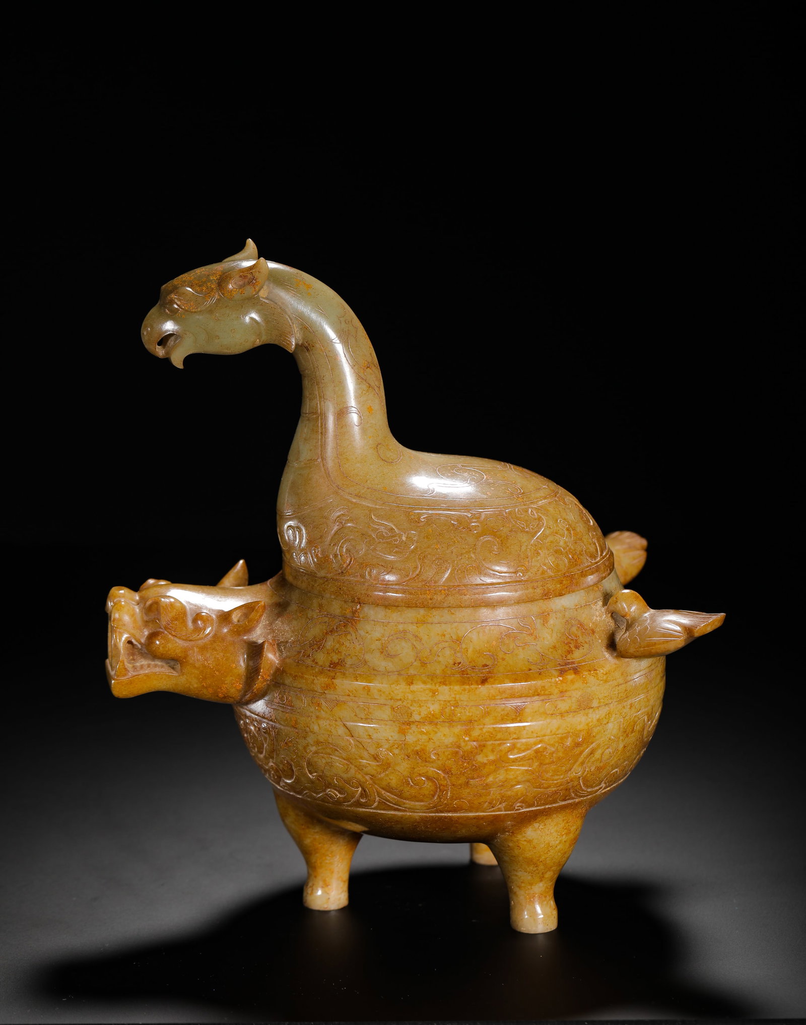 HAN DYNASTY HETIAN JADE AUSPICIOUS BEAST PATTERN THREE-LEGGED He: H:23cm (9.06in) W:17.5cm (6.89in) Weight:1460g (3.22lb)This is a Han Dynasty Hetian jade tripod he vessel with natural yellowish-brown patina, carved with a phoenix-head finial, beast-head spout, and 