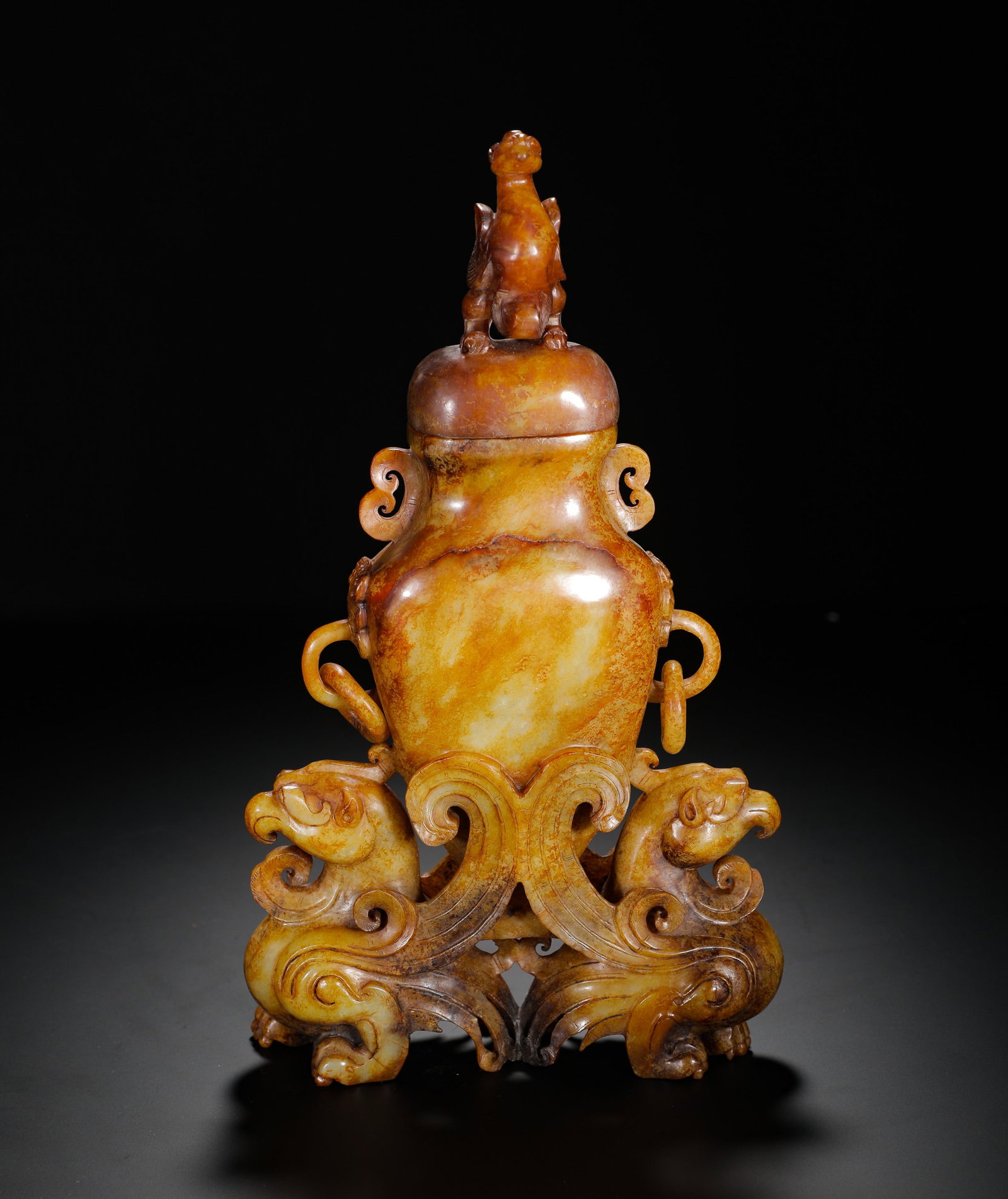 A HAN DYNASTY HETIAN JADE DOUBLE-PHOENIX-SHAPED VASE WITH A TINTED COLOR: H:34cm (13.39in) W:18.5cm (7.28in) Weight:1890g (4.17lb)This is a Han Dynasty Hetian jade display vessel with yellowish-brown patina, supported by a pair of phoenixes and topped with a carved bird fin