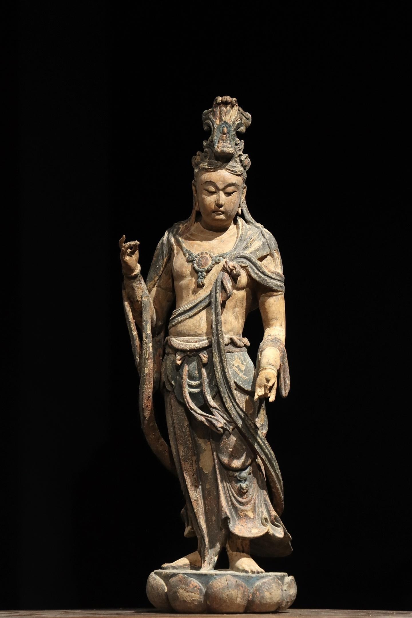 A STANDING STATUE OF GUANYIN CARVED AND PAINTED IN WOOD FROM THE TANG DYNASTY: H:60cm(23.62in)Wood-carved Bodhisattva statue with residual painted decoration. A small Buddha figure is set inside the crown. It has a mild and tranquil face, adorned with necklaces and flowing scarv
