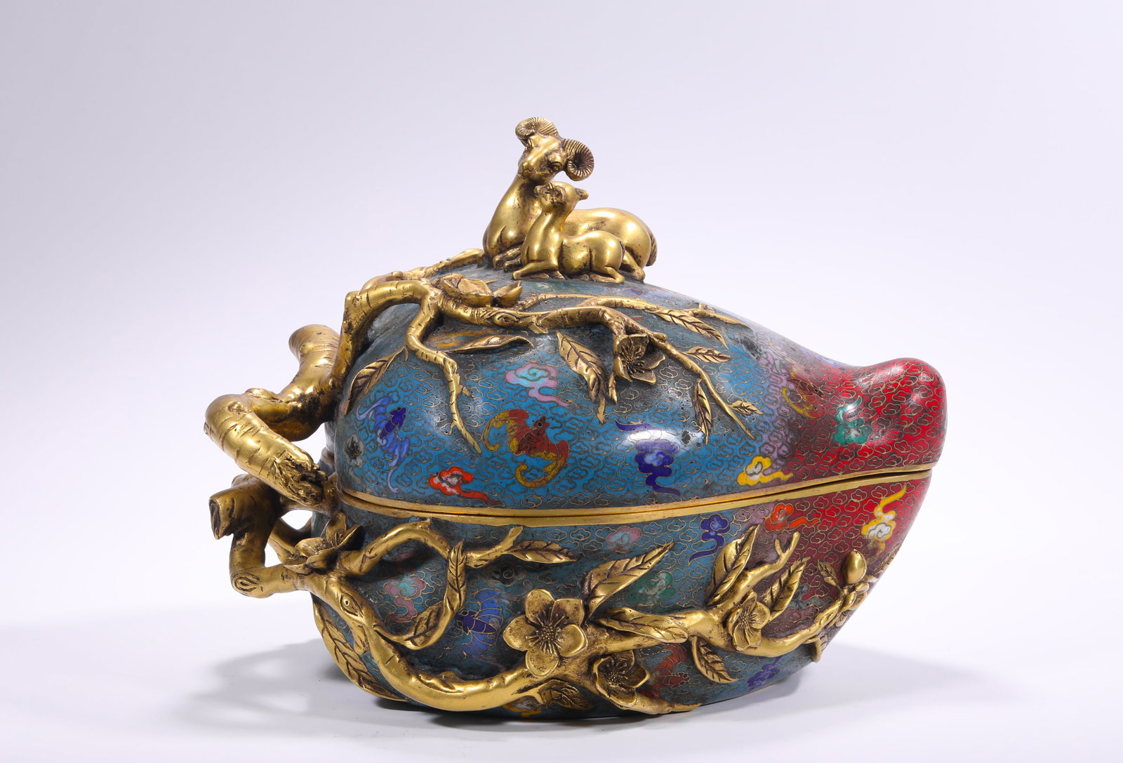 BRONZE CLOISONNE ENAMEL GILDED PEACH-SHAPED LID BOX OF THE QING DYNASTY: H:20.0cm(7.87in) W:24.0cm(9.45in) Weight:5910g(13.03lb)This box is a top-tier palace cloisonne vessel of the Qing Dynasty, made of bronze with full-body cloisonne enamel craftsmanship. It features the