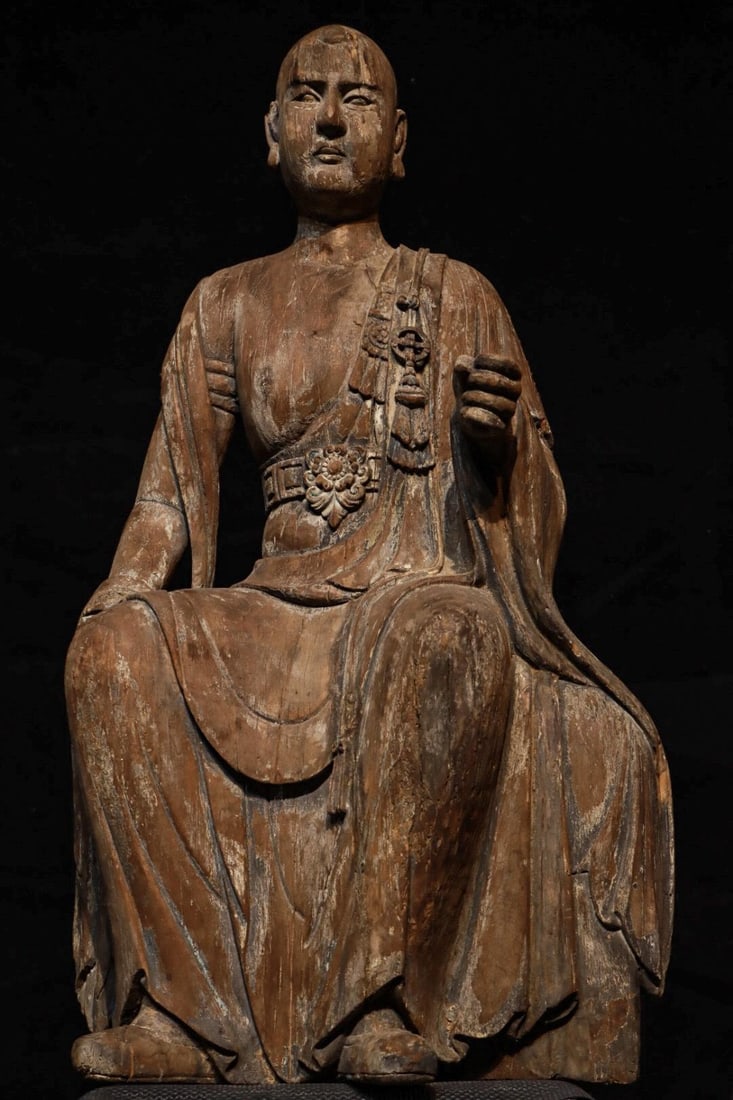 MING DYNASTY NANMU SEATED ARHAT: H:100cmL:60cmW:38cm The style of this statue combines the solemnity of the Ming Dynasty statues with the secular characteristics of the Qing Dynasty statues. It is a typical representative of the tran