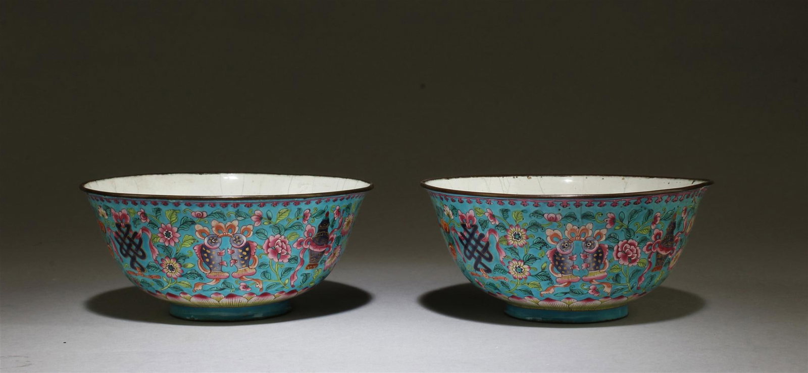 Pair of Chinese Cloisonne Bowls: China, 19th C., a pair of cloisonne bowls, flared lip, undulating sides to flat base, exterior sides with dense decoration of blossoming flowers, vines and symbols against bright blue ground. Height: 