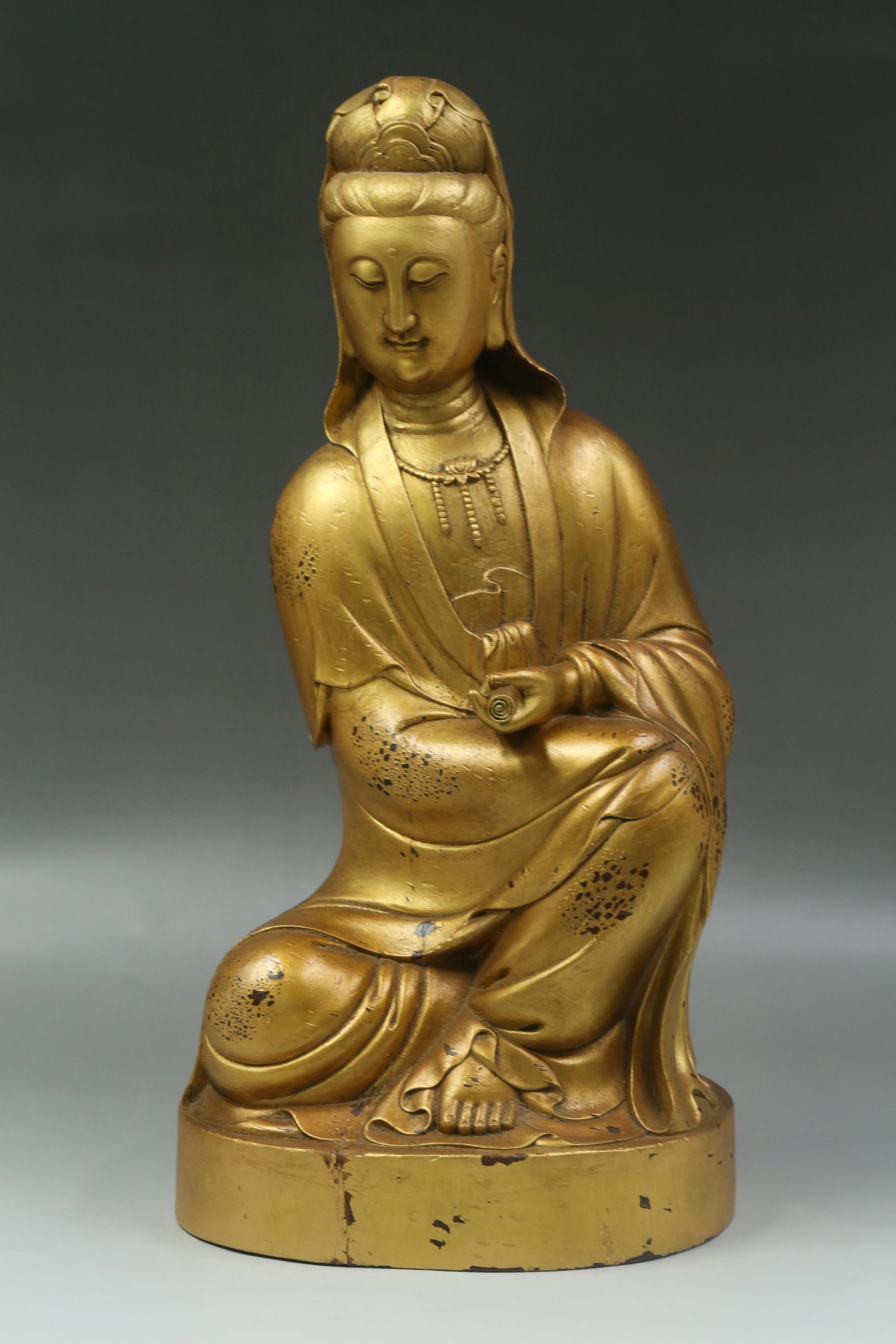 A Gold Pasted Wood Carved Guanyin Statue: A Gold Pasted Wood Carved Guanyin Statue. Dimension: 17" x 8.5" x 7.5".