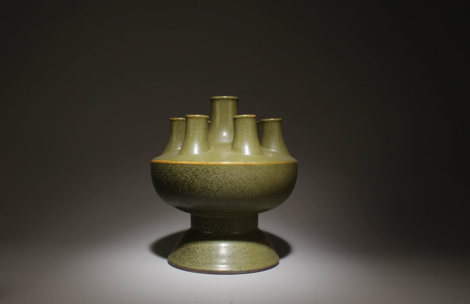 A Green Glazed Seven-Hole Vase: A Green Glazed Seven-Hole Vase. Dimensions: 8.5" x 9.5".