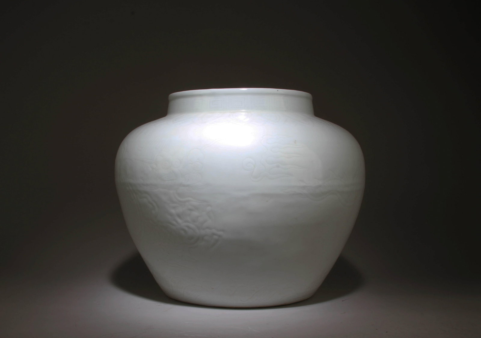 A White Porcelain Jar with Dragon Motif: A White Porcelain Jar with Dragon Motif. Dimensions: 13.5" x 11".