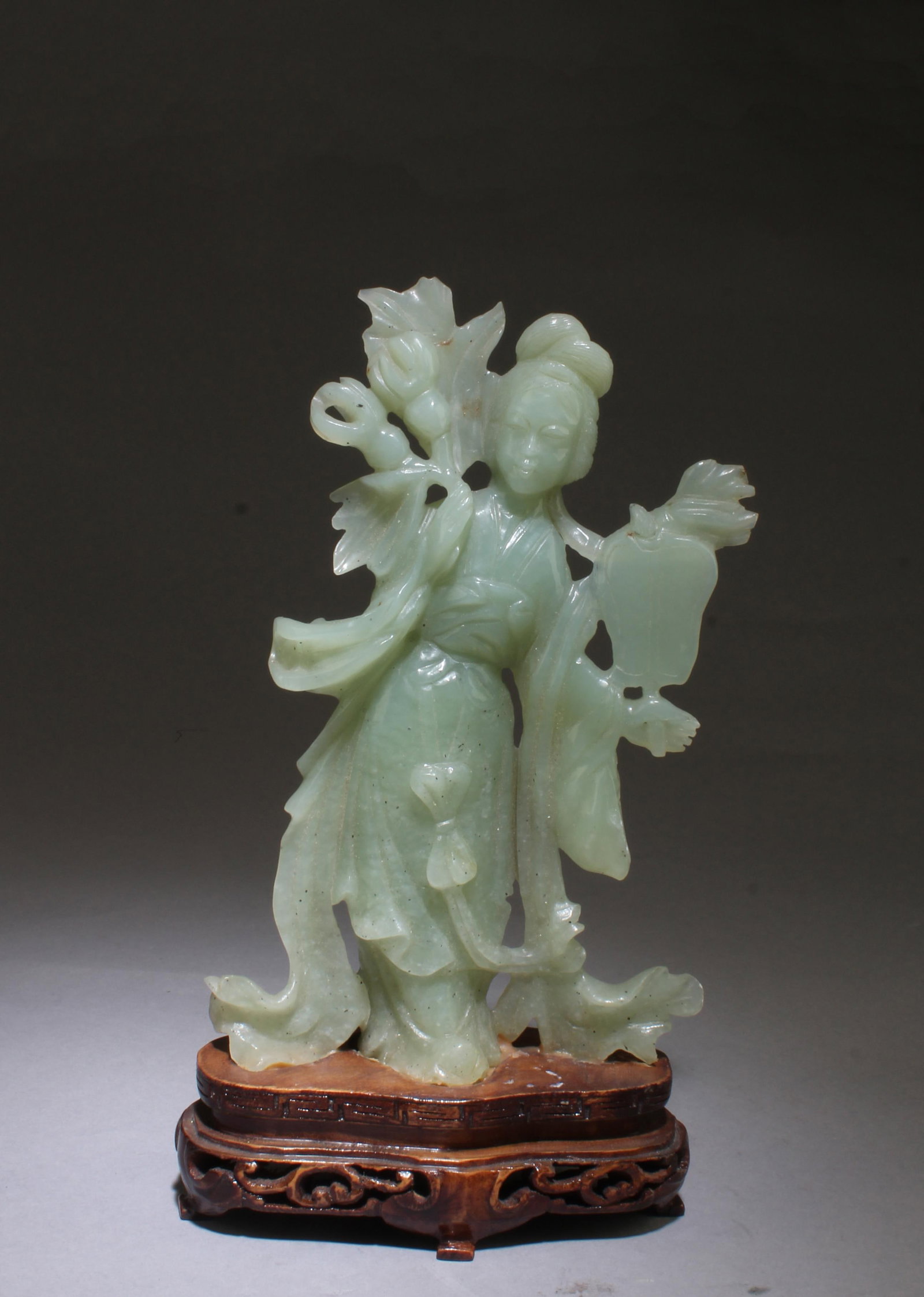 A Carved Jade Maiden Figurine: A Carved Jade Maiden Figurine. Comes fiited with a wooden stand. Height: 7.75"