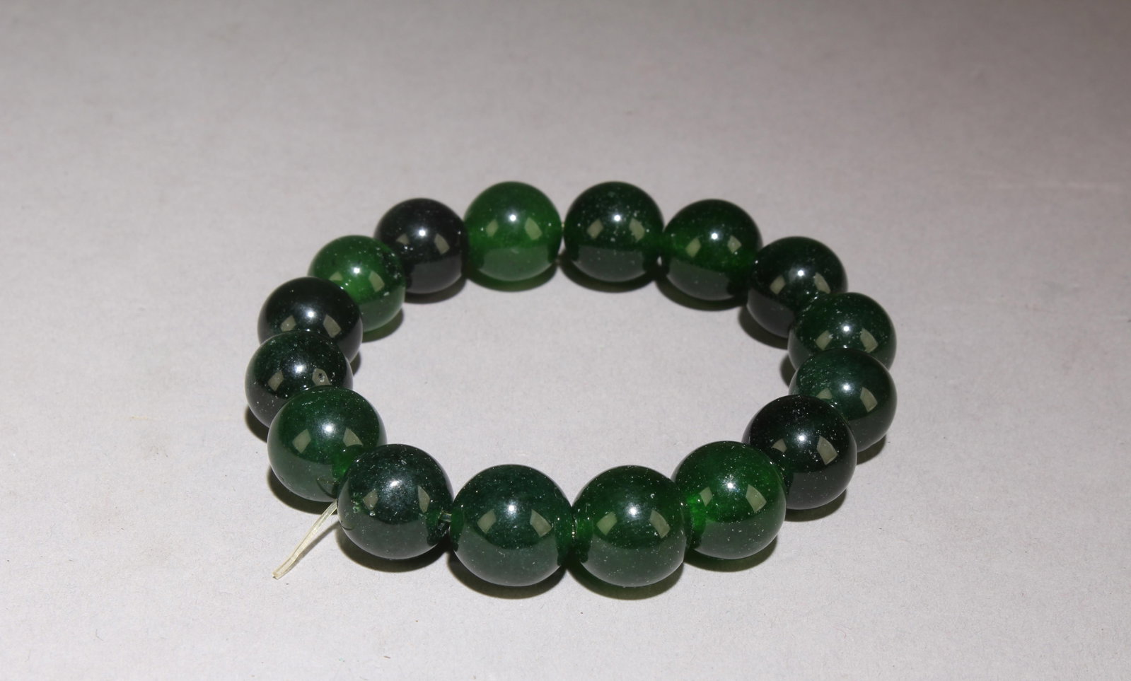 A Jade Bracelet: Jade Bracelet. Diameter: 3", Bead Size: 0.4".
