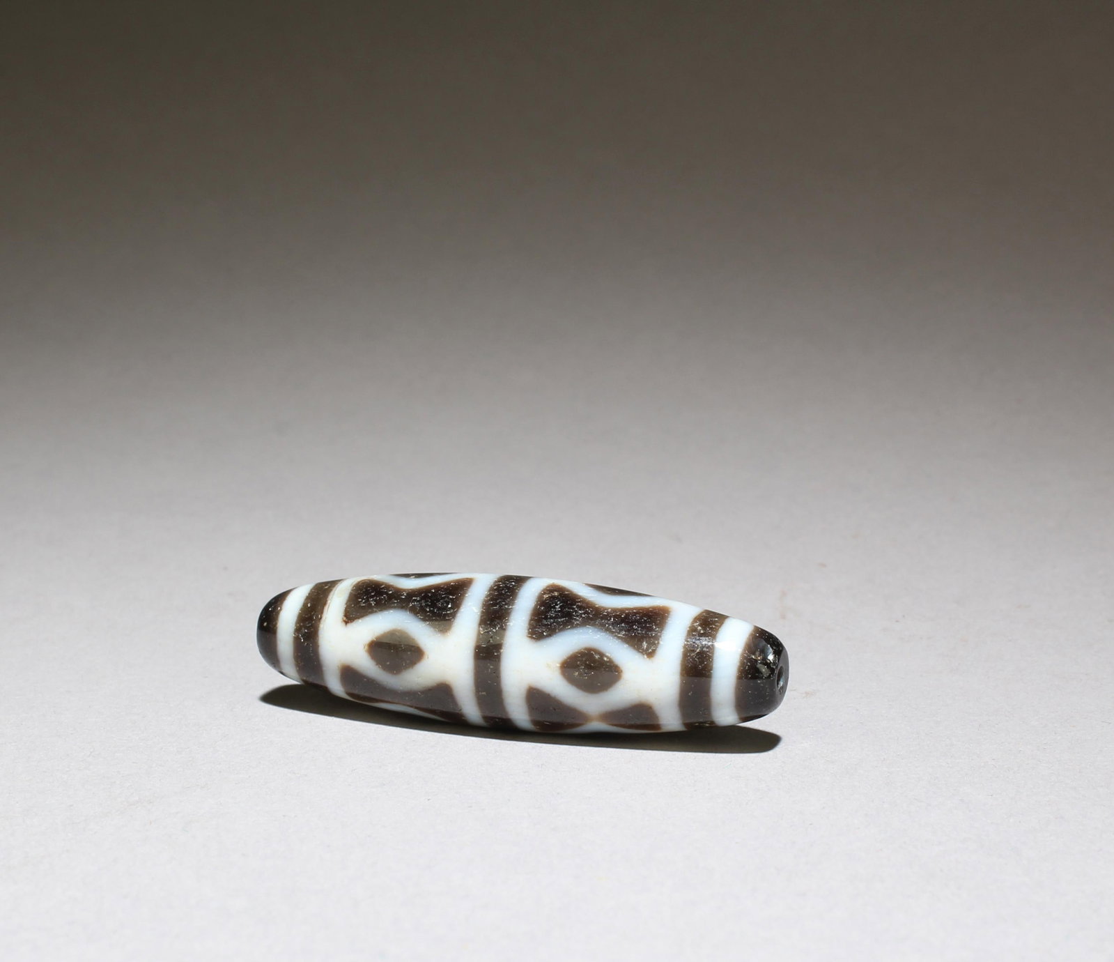 A Dzi Bead: A Dzi Bead. Length: 1.75"