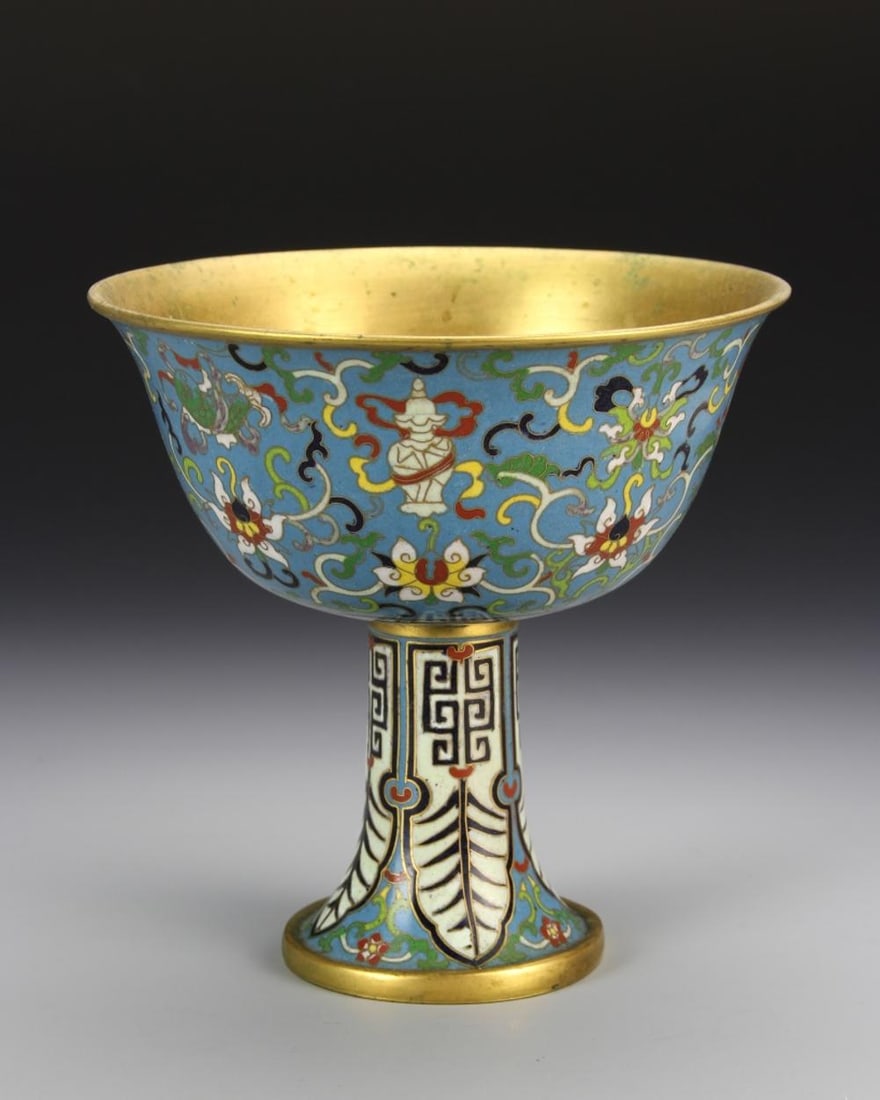 Chinese Cloisonne High Stem Bowl: 18th C., cloisonne high stem bowl, with flared base and rim, blue ground with auspicious symbols and floral motifs, gilt band at base, with Qianlong mark. Height 6 1/2 in., Diameter 6 1/4 in.