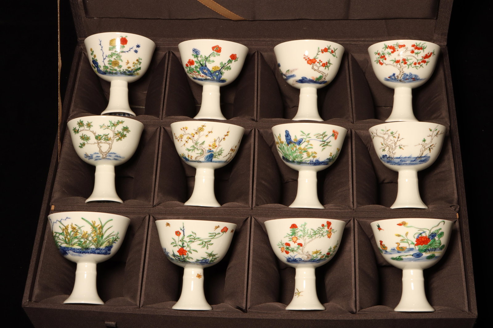 A Group of Twelve Doucai Glazed Cups: A Group of Twelve Doucai Glazed Cups."KangXi" mark at base, Box Dimension: 16.2" x 13" x 4". Cup Dimensions: 3.1" x 3"