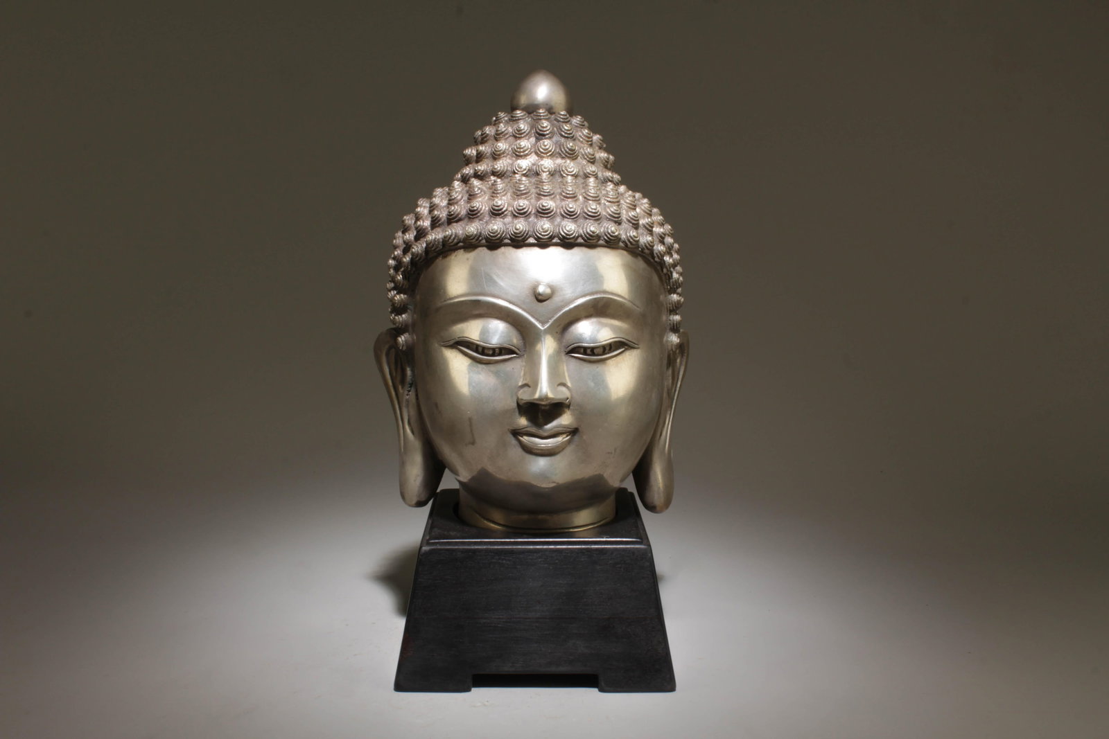 A Bronze Buddha Head with Stand: A Bronze Buddha Head with Stand. Dimension: 5" x 11" w/ stand.