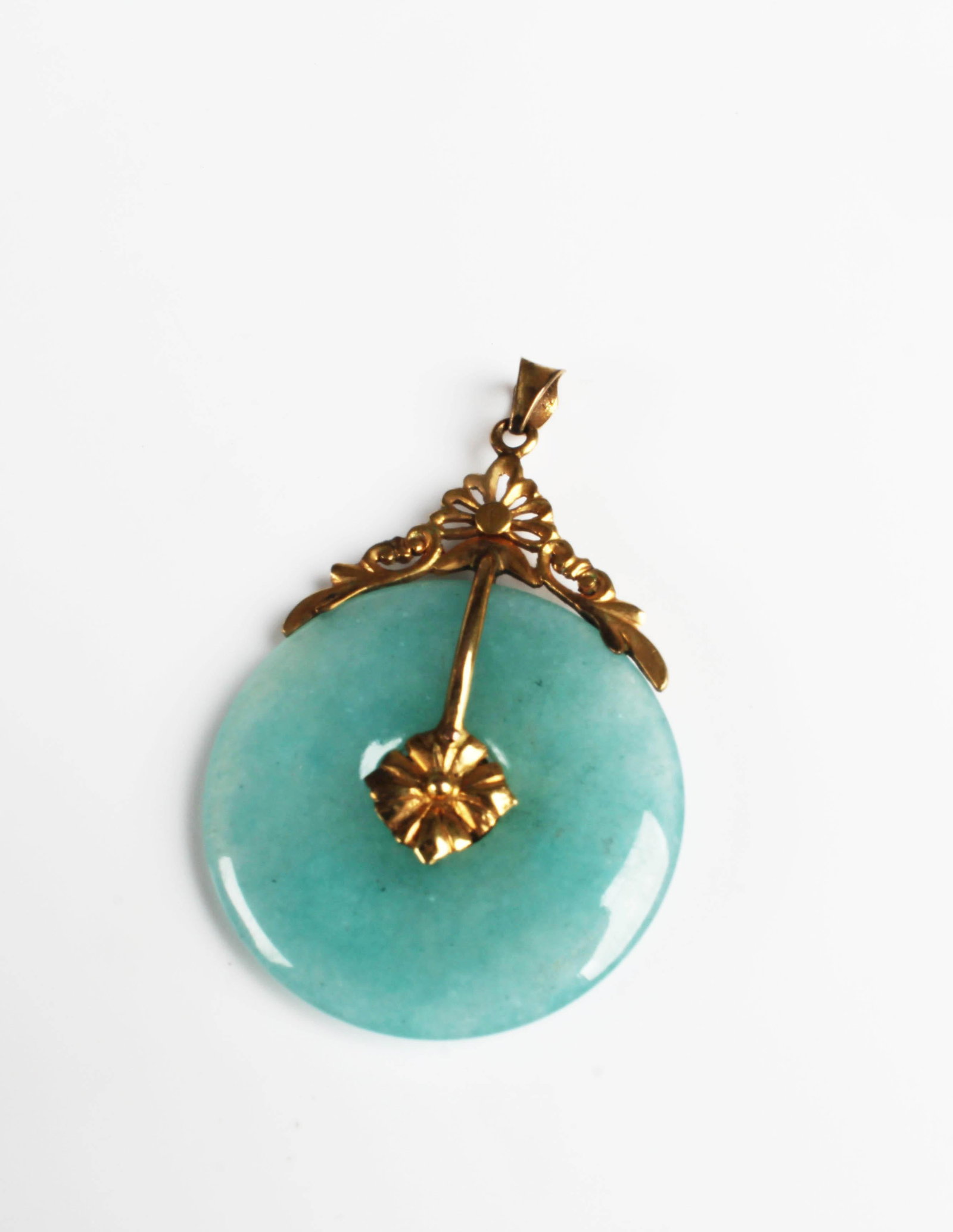 Chinese Jadeite Pi Pendant: Chinese jadeite pi pendant, round body with green hues throughout with decorative gold pin, carved with petal formation and pointed clasp at the top. Diameter: 1.25"