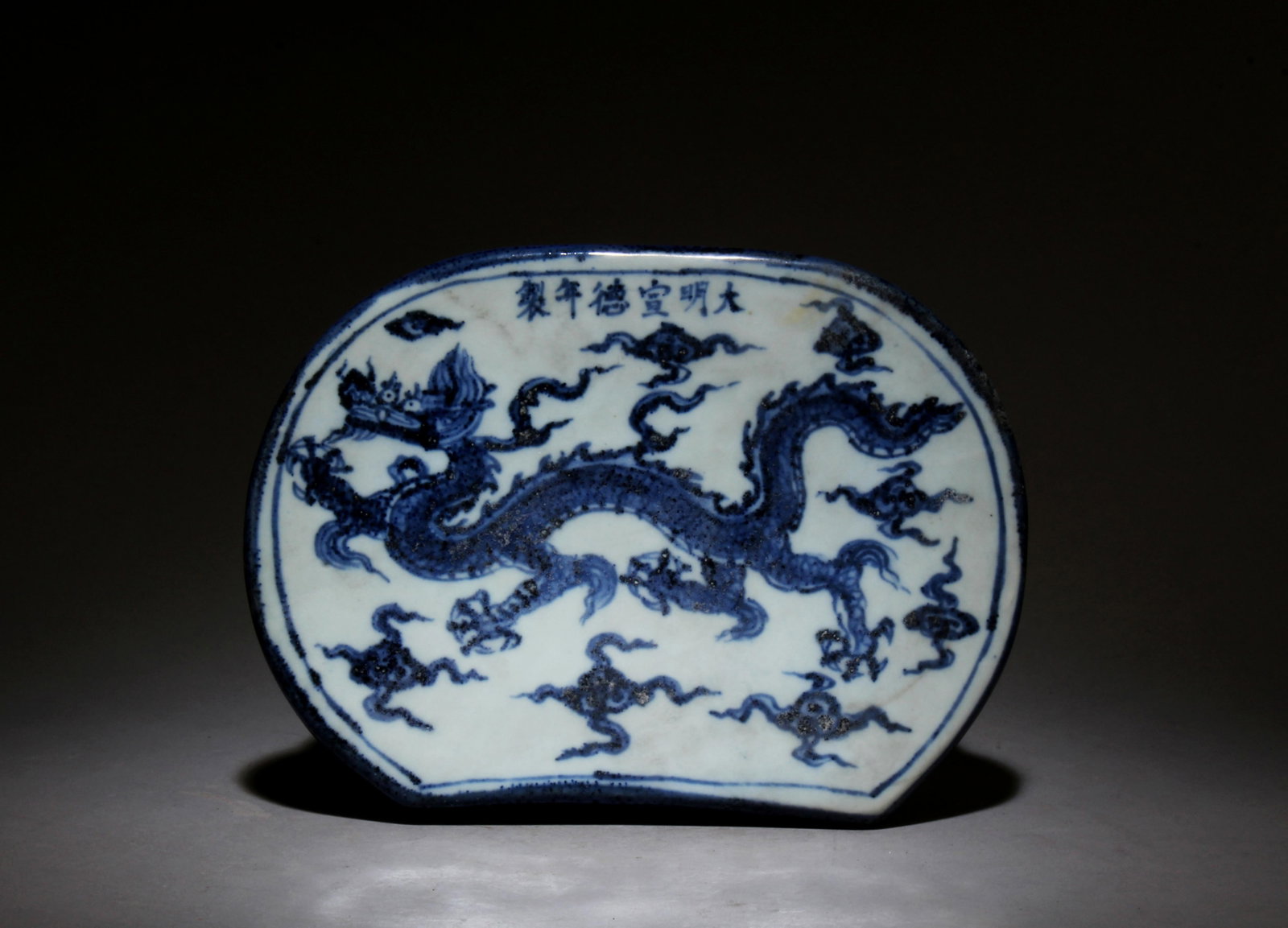 A Blue and White Pillow: A Blue and White Pillow. Dimensions: 3.75" x 1.6".