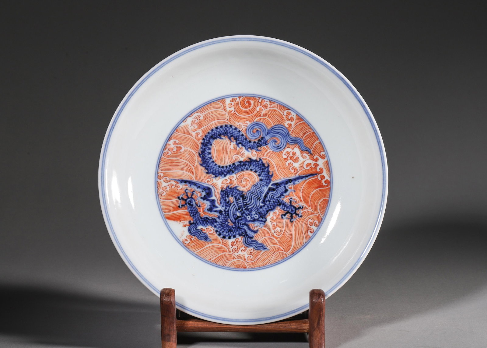 A BLUE AND WHITE DISH WITH WINGED DRAGON AND SEA CREATURES ON IRON-RED WAVE GROUND, XUANDE PERIOD: W 19cm (7.48 in); H 4cm (1.57 in),A Ming Xuande shallow dish, interior center with winged dragon amid iron-red rolling waves. Inner and outer walls decorated with various mythical sea beasts on iron-r