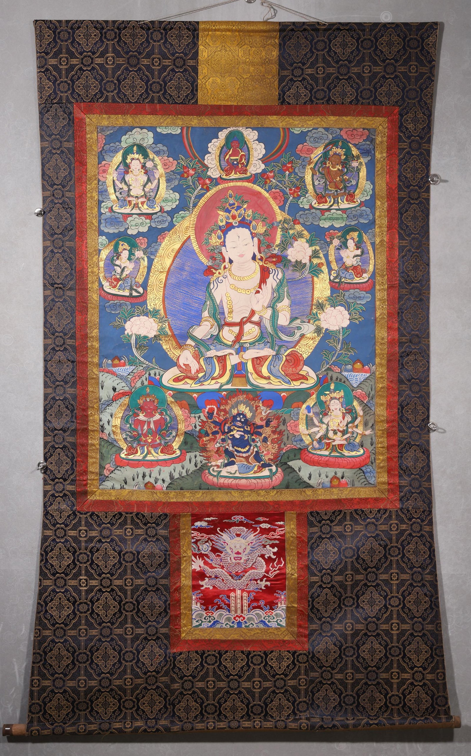 A White Tara Thangka - Qing Dynasty: Length 100.0cm (39.37in), Width 76.0cm (29.92in)This Qing Dynasty thangka depicts White Tara, painted with mineral pigments on cotton. The central Tara sits serenely in lotus posture, with her compass