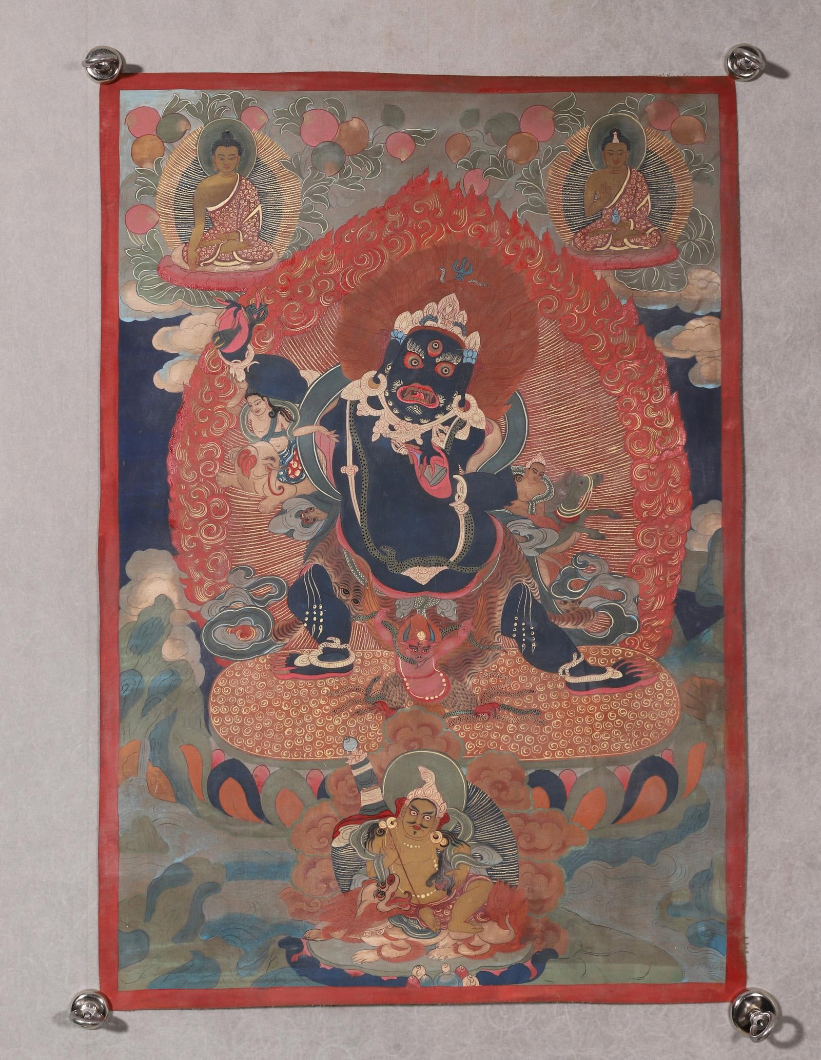 A GREAT RED LORD OF THE LIFE THANGKA, QING DYNASTY: L 60cm (23.62 in); W 40cm (15.75 in),This Qing Dynasty thangka depicts the Great Red Lord of the Life, surrounded by flames, with Yellow Jambhala below and two Buddhas above. With simple lines and anc