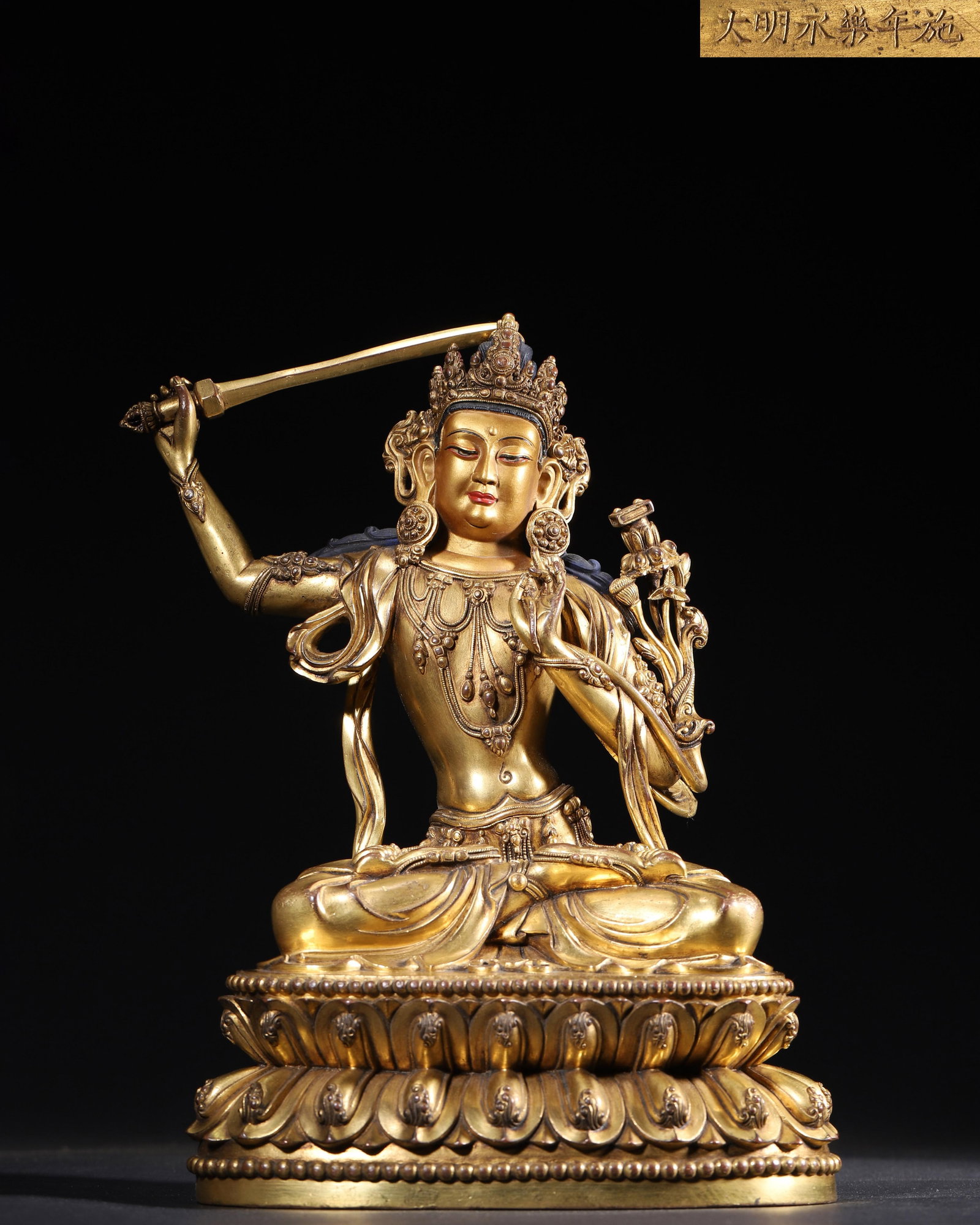 IMPERIAL COMMISSIONED GILT-BRONZE FIGURE OF MANJUSHRI, MING DYNASTY, YONGLE PERIOD: 7.48" x 5.12" x 10.63" inches (19.0 cm x 13.0 cm x 27.0 cm) (Main) | Weight: 7.42 lbs (3364.0 g)A fine imperial gilt-bronze figure of Manjushri, Yongle period, Ming Dynasty. Exquisitely cast with rich