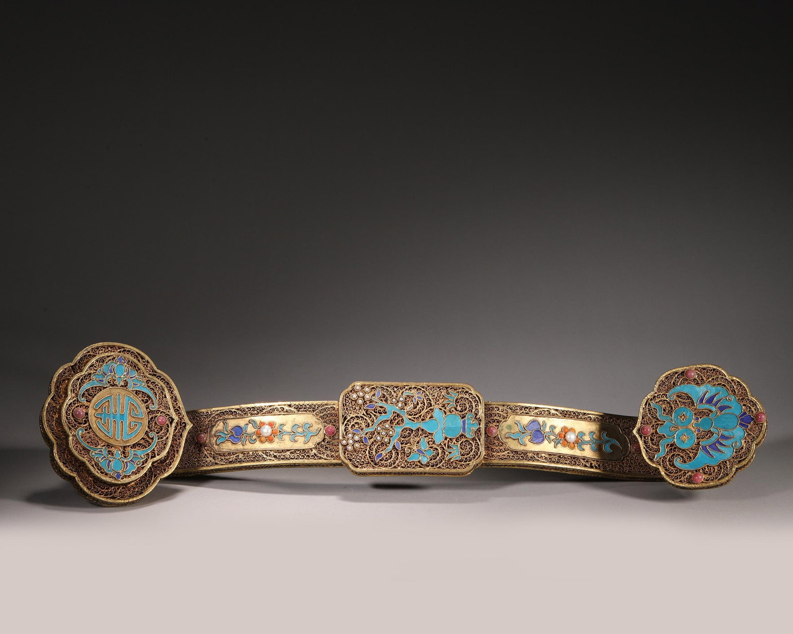 A Silver-Gilt Filigree Ruyi Scepter with Kingfisher Feather and Gem Inlay, Qing Dynasty: L 45.0cm (17.72 in); W 10.5cm (4.13 in); Wt 687.0g (1.51 lb)This ruyi scepter is crafted from silver-gilt with filigree technique. Decorated with kingfisher feather inlaid longevity, bat and gourd pat