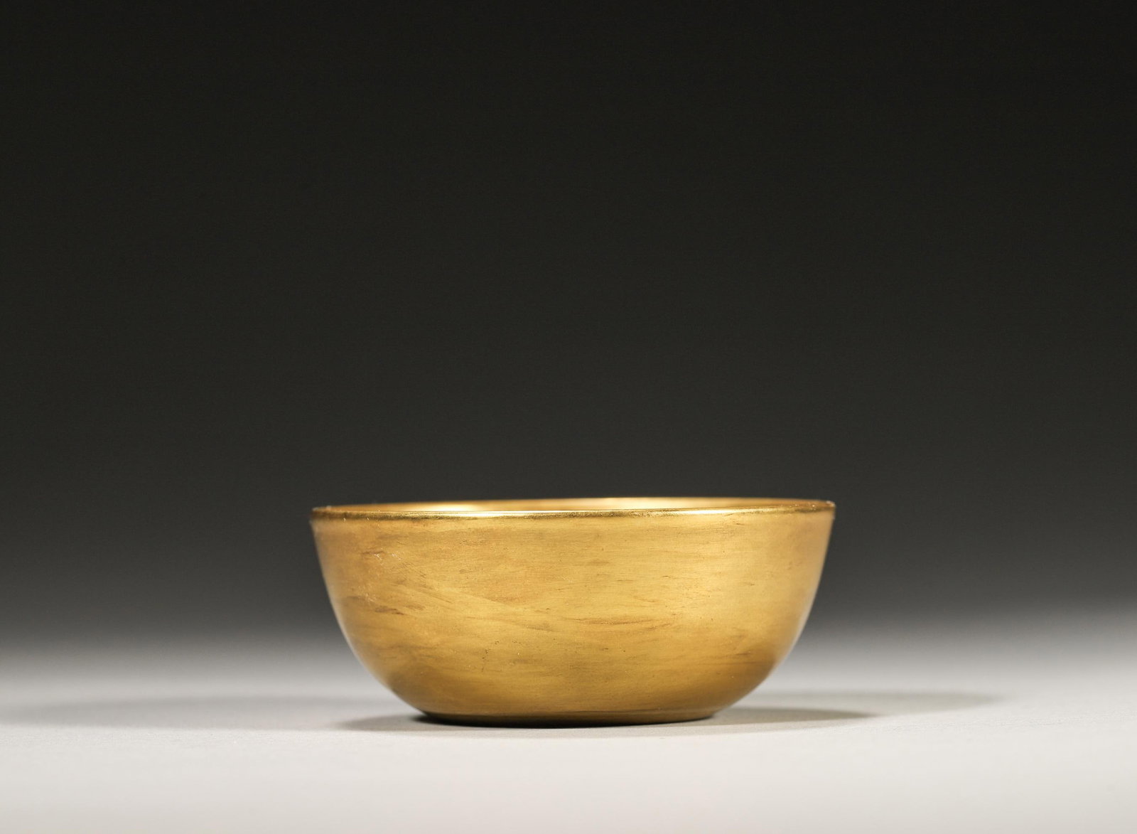 A FINE GILT-GLAZED BOWL, YONGZHENG MARK AND PERIOD, QING DYNASTY: W: 5.8cm (2.28in) H: 2.5cm (0.98in)A superb Yongzheng period gilt-glazed bowl, covered in rich golden glaze, elegant shape, standard imperial mark, extremely rare, high collection value.