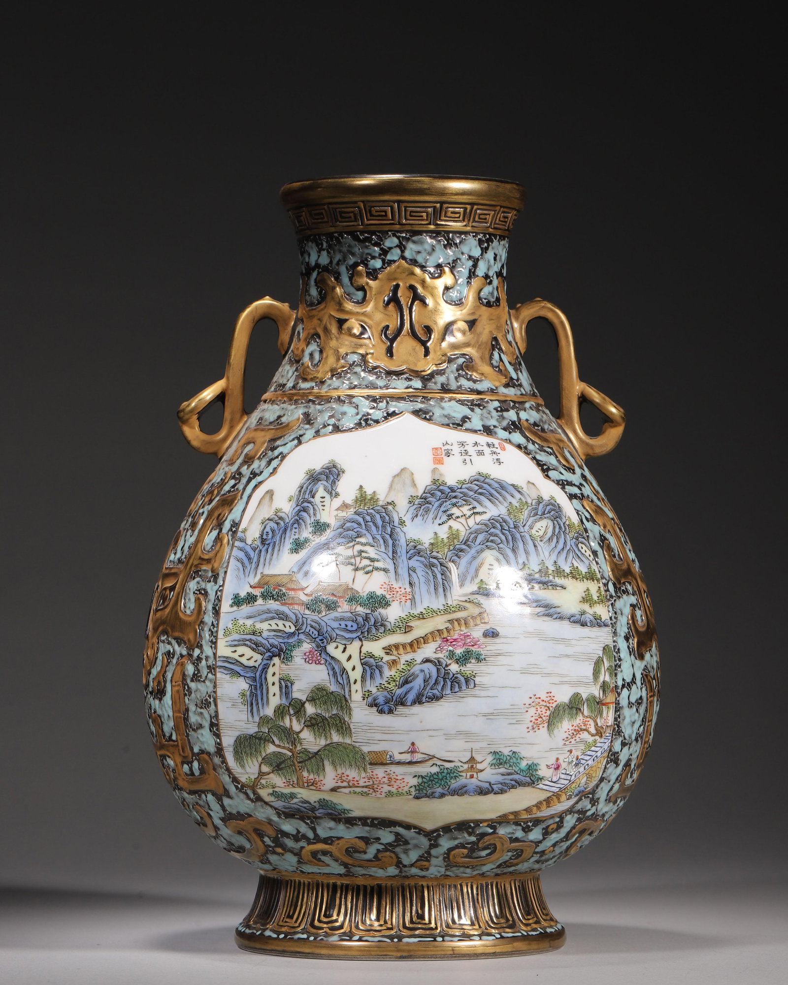 A CARVED GILT PORCELAIN ZUN WITH RUYI HANDLES, STONE-GROUND FAMILLE ROSE LANDSCAPE PANELS, QIANLONG: H 29.00cm (11.42 in); D 18.00cm (7.09 in),Qianlong marked porcelain zun with gilt ruyi handles. Black turquoise stone imitation ground carved with gilt archaic beast patterns. Four panels painted fami