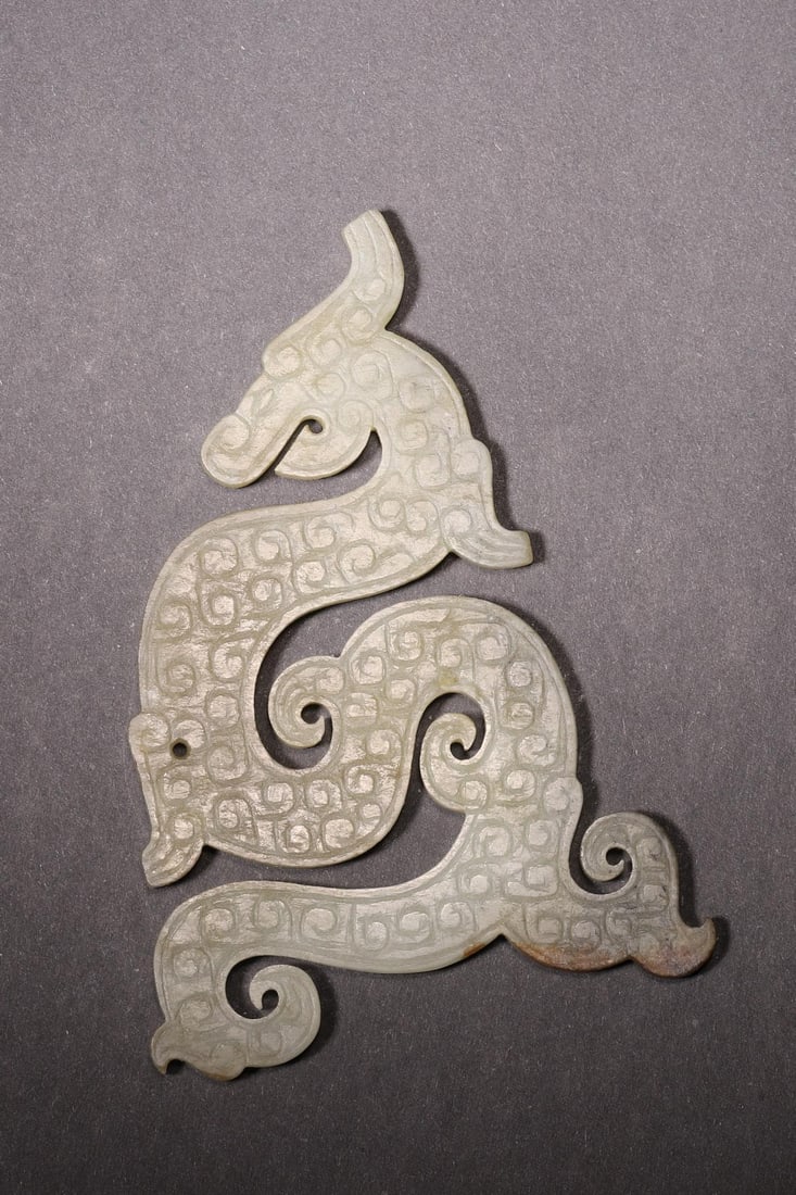 A - Hetian Jade S-shaped Dragon Pendant, Warring States Period: L 10.5cm (4.13 in); W 7.5cm (2.95 in); Wt 56g (0.12 lb)Crafted from Hetian jade, this pendant features a smooth S-shaped dragon form with sharp cloud patterns, flowing curves, and natural patina. It i