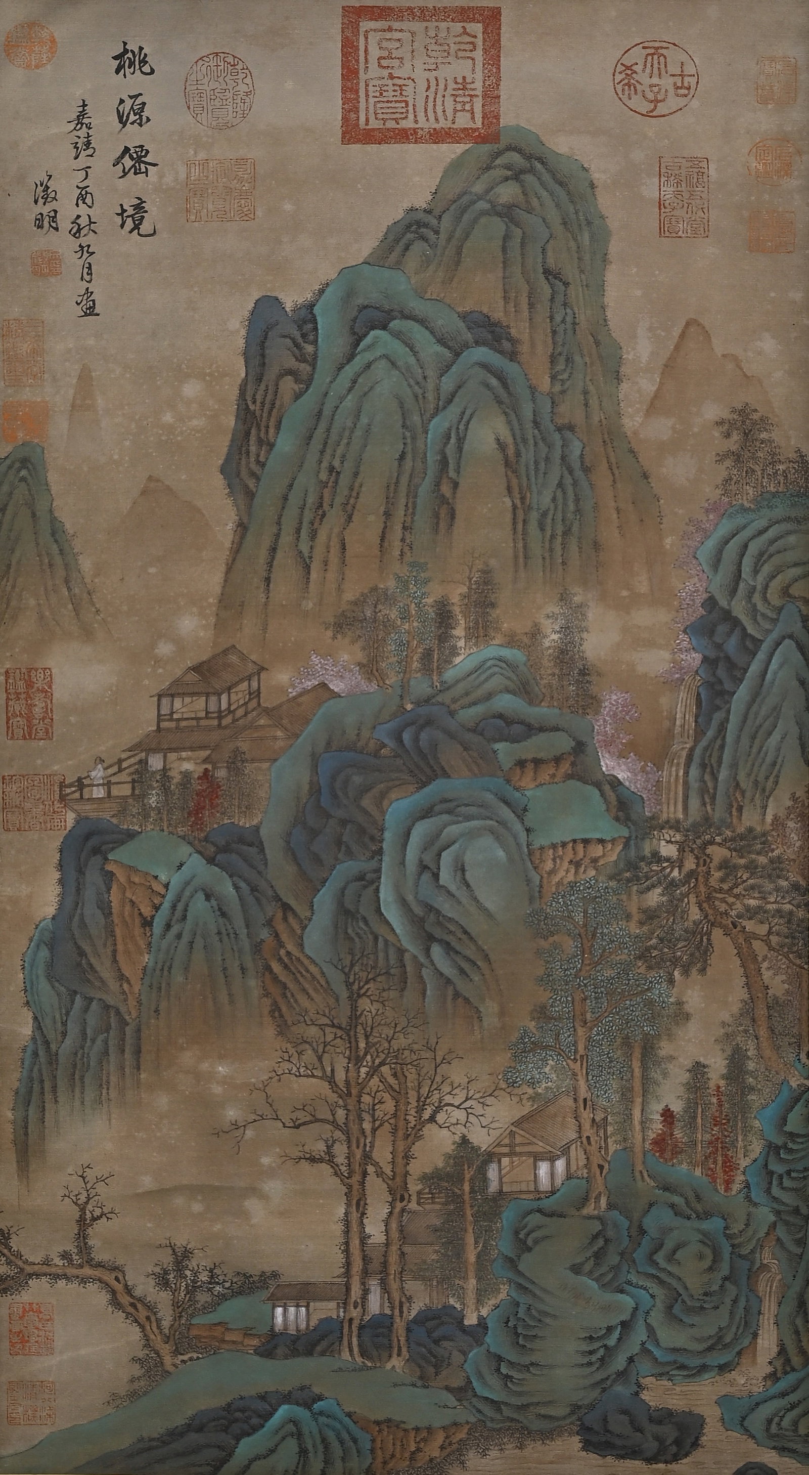 A Vertical Silk Scroll of Peach Blossom Fairyland by Wen Zhengming, Ming Dynasty: Image Core H 88.0cm (34.65 in); W 43.0cm (16.93 in)This Ming Dynasty green-blue landscape on silk is painted by Wen Zhengming, featuring layered mountains and secluded cottages, inscribed and stamped 