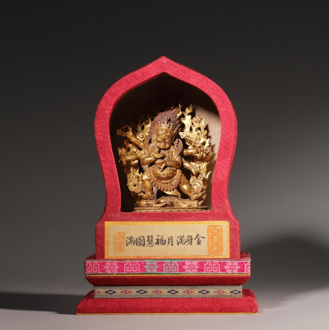 A Gilt Bronze Six-Armed Mahakala Statue, Qing Dynasty: Buddha H 13cm (5.12 in); Buddha L 10cm (3.94 in); Buddha W 6cm (2.36 in); Wt 474g (1.04 lb)A Qing Dynasty gilt bronze six-armed Mahakala statue, with fierce expression, holding ritual implements, tram