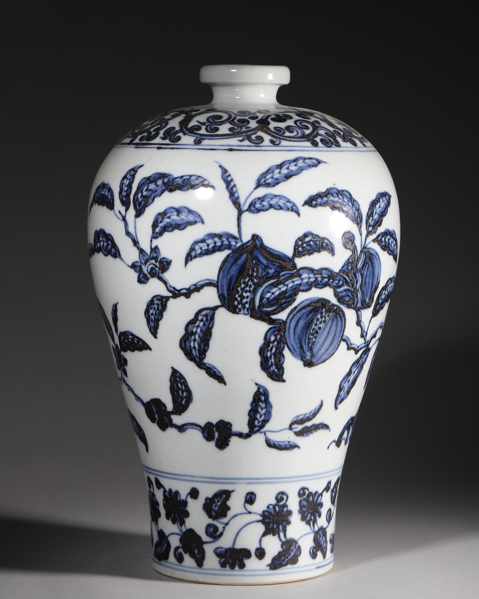 A BLUE AND WHITE POMEGRANATE MEIPING VASE, YONGLE PERIOD, MING DYNASTY: L 22cm (8.66 in); H 40cm (15.75 in),An imperial Ming Yongle porcelain meiping painted with pomegranate branches in imported cobalt blue. Decorated with scroll foliage on shoulder, fruit sprays on body